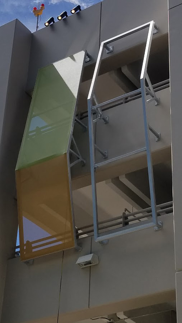 A process photo of the facade screening being installed on a steel cladding frame.