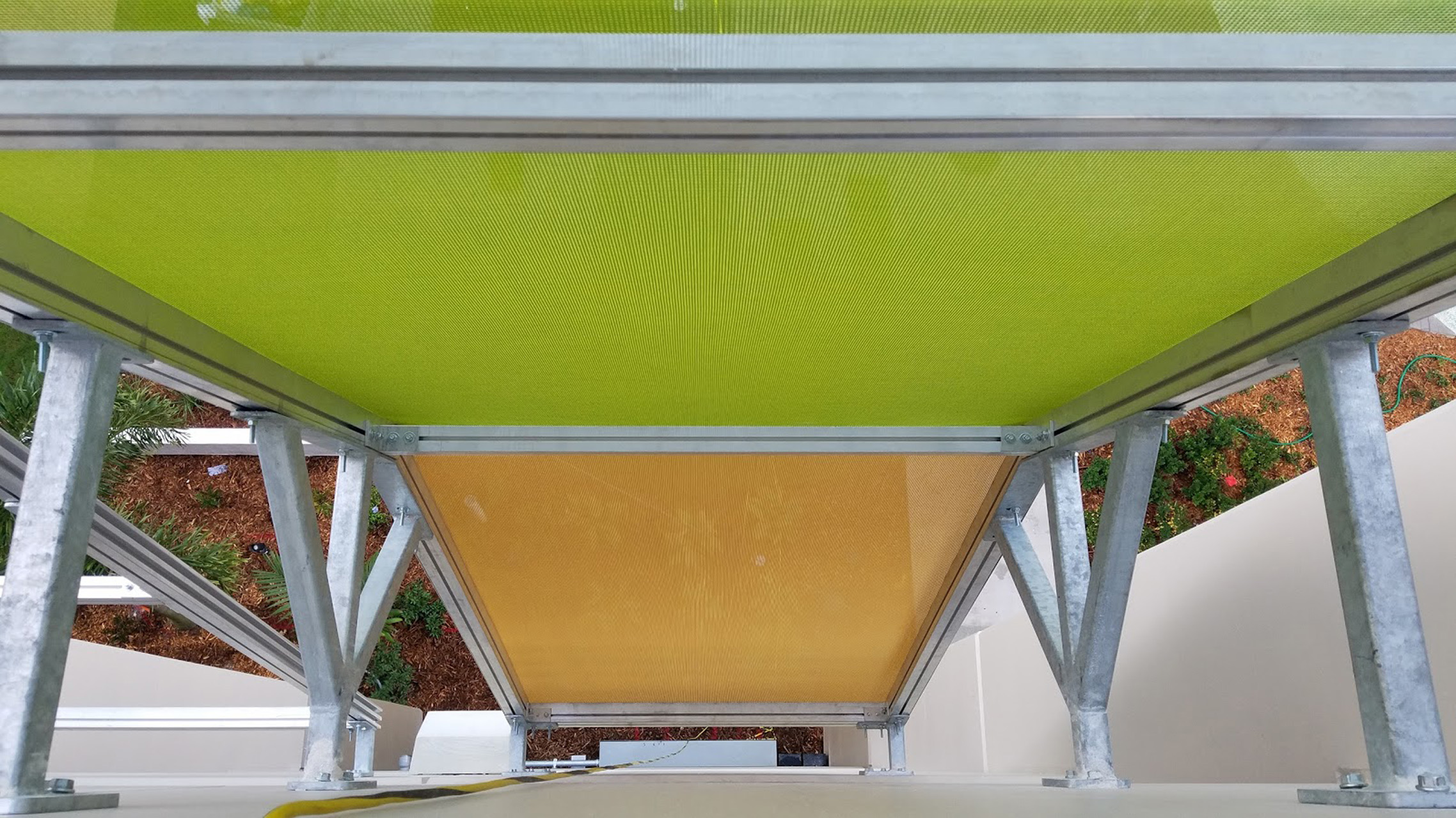 A view from the top of the parking garage looking down into the gap between the facade and the structure, revealing there facade slightly convex's out..