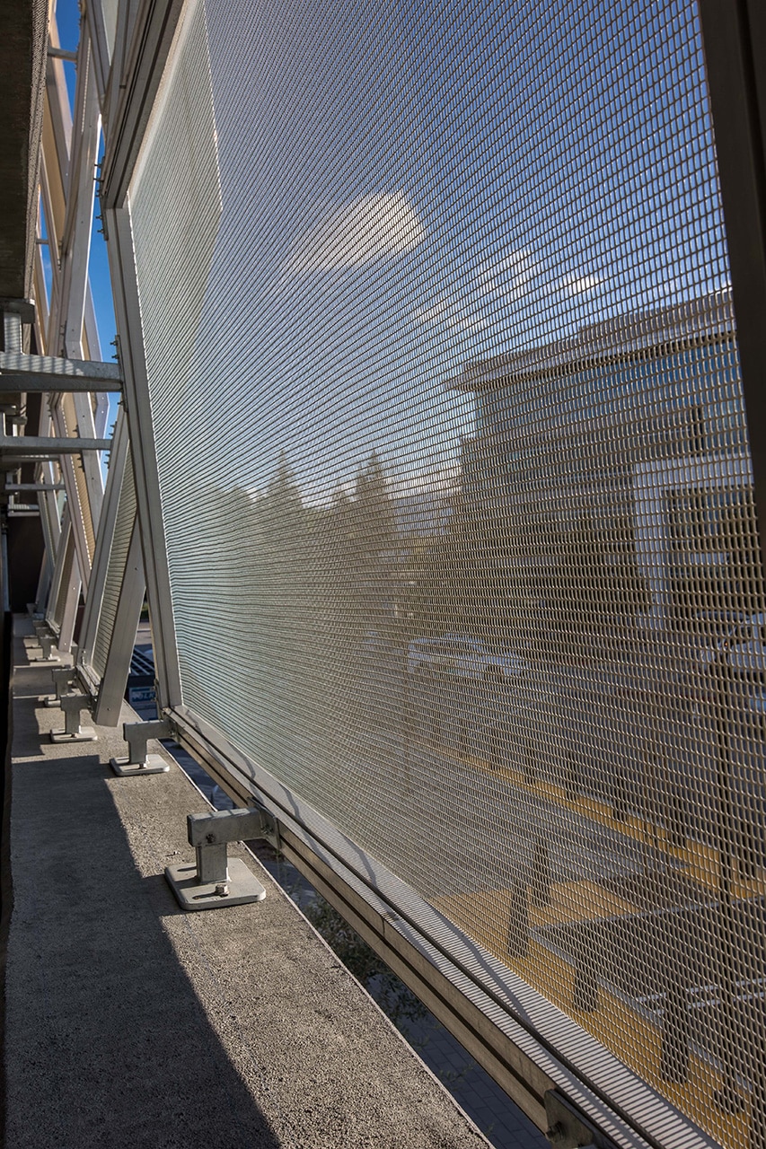 A view from the inside of the parking structure looking out through the facade.