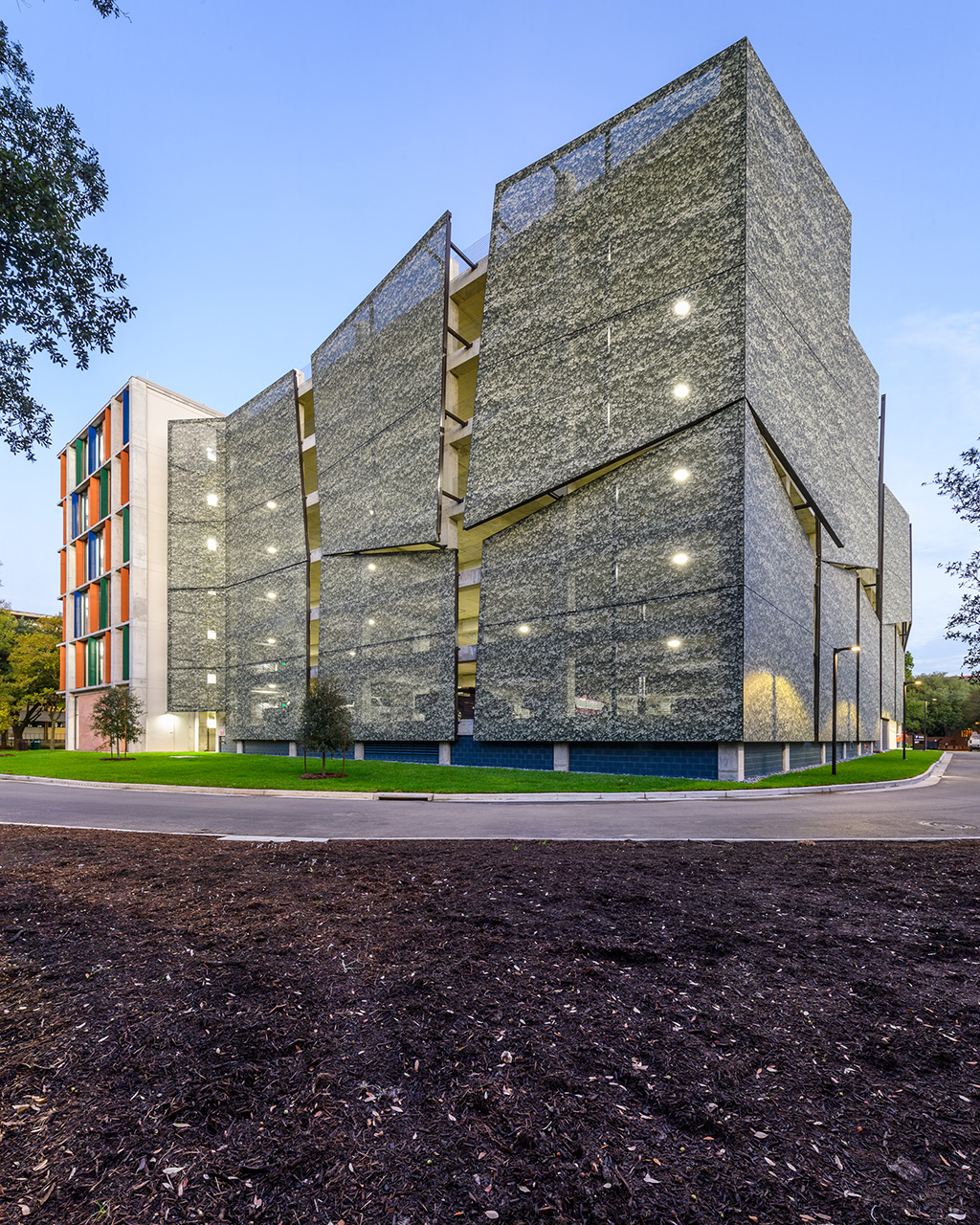A green leaves graphic printed facade that has multiple different panels that stick out at every angle creating a 3D effect.
