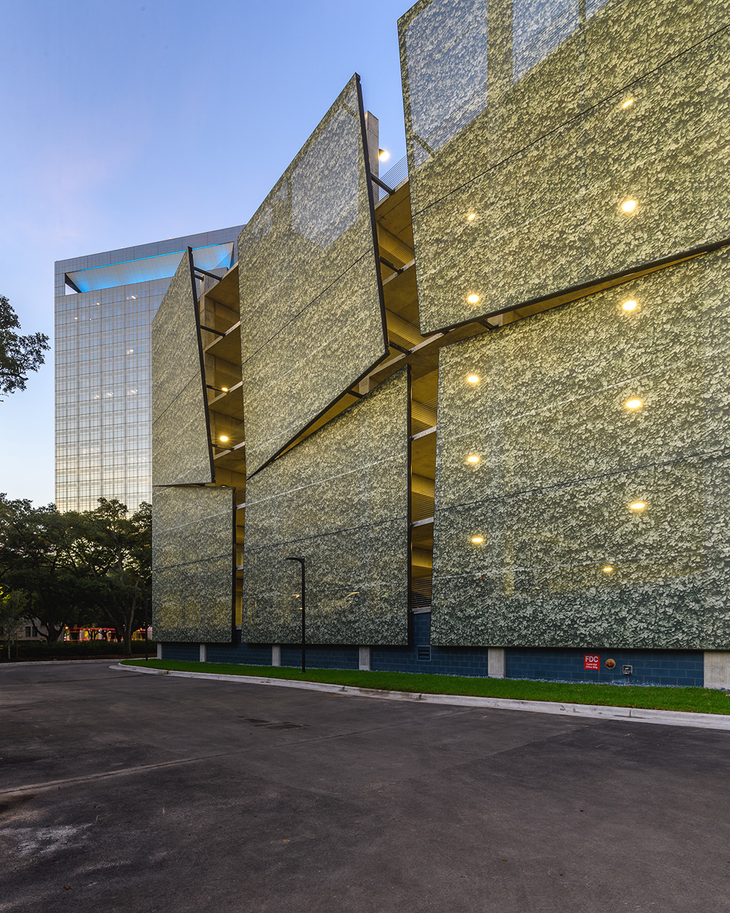 A green leaves graphic printed facade that has multiple different panels that stick out at every angle creating a 3D effect.