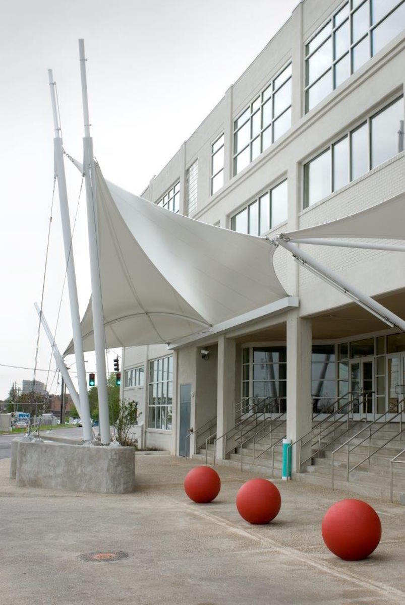 Different winged facades that are overlapping in front of the building enterance.