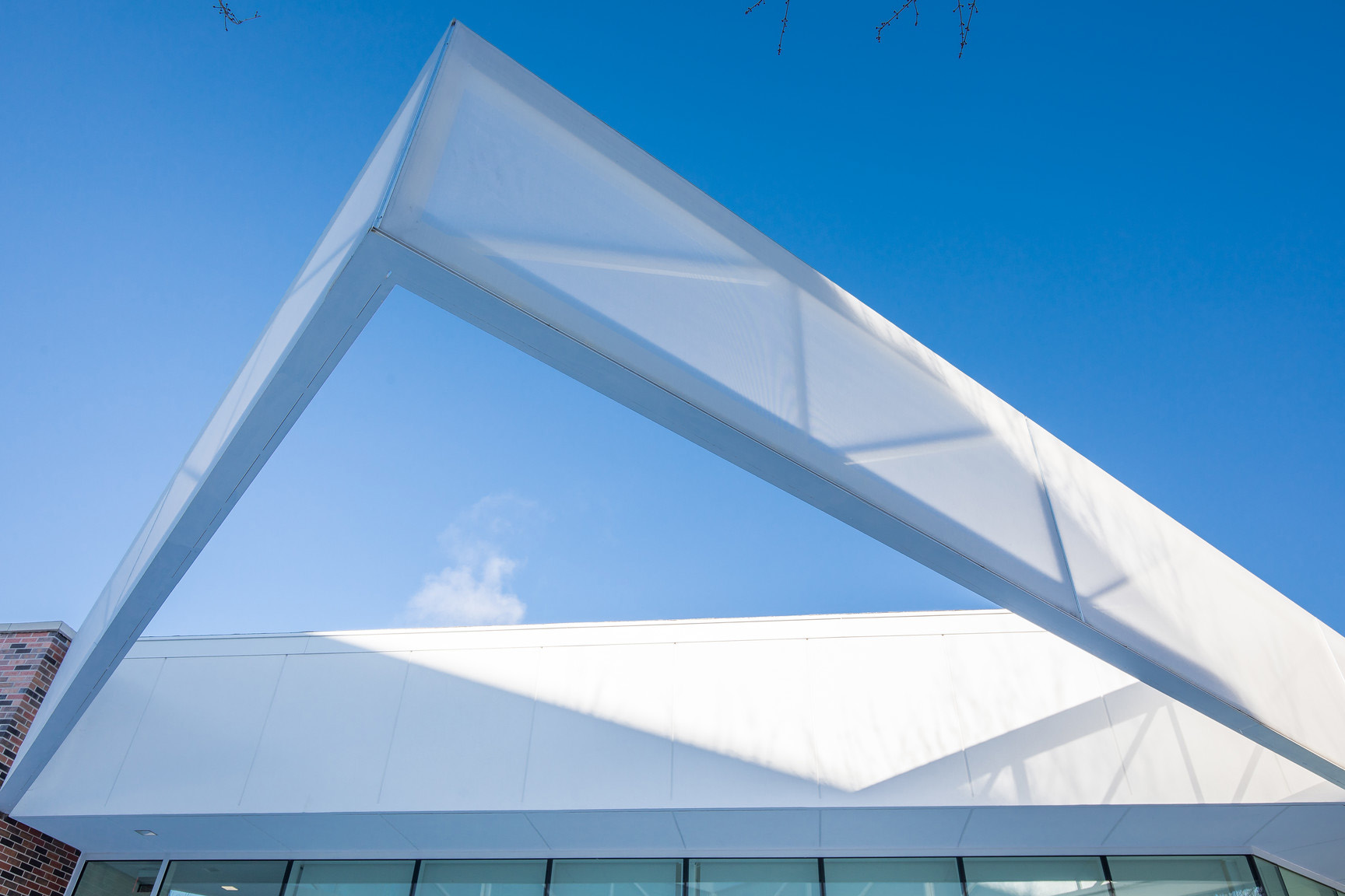 A view of the triangular part of the facade during the day.