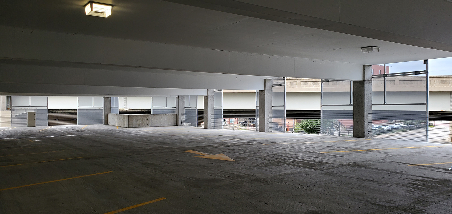A view from inside of the parking structure looking out through the facades.