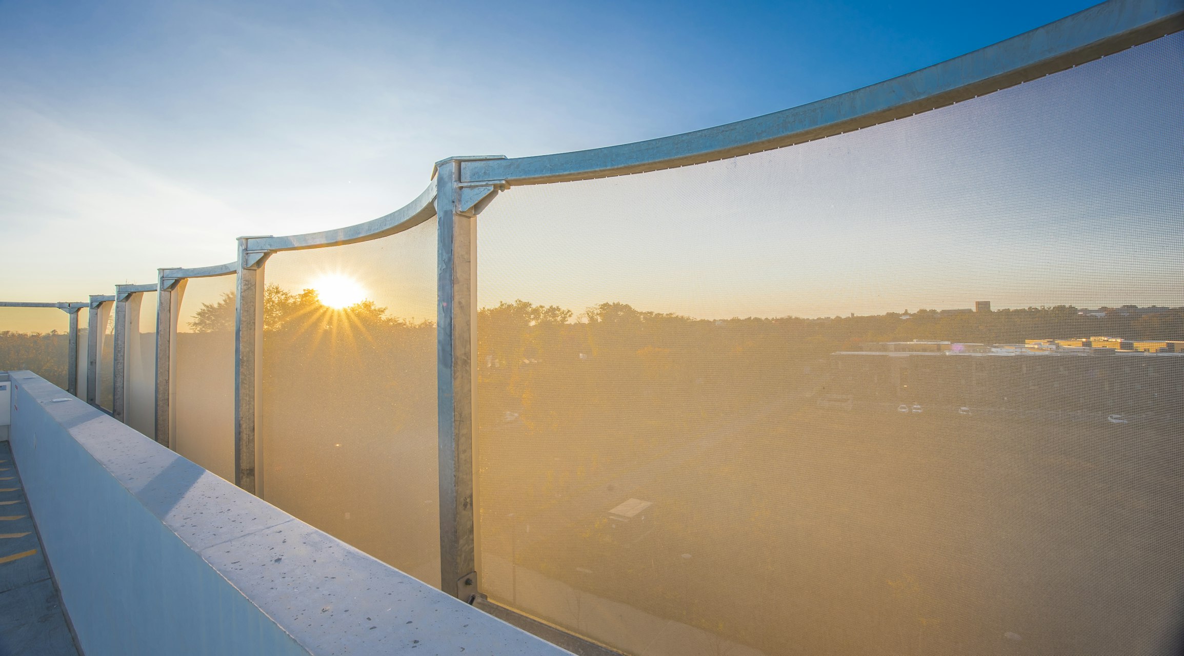 A view from the top of the parking garage looking out through the facade.
