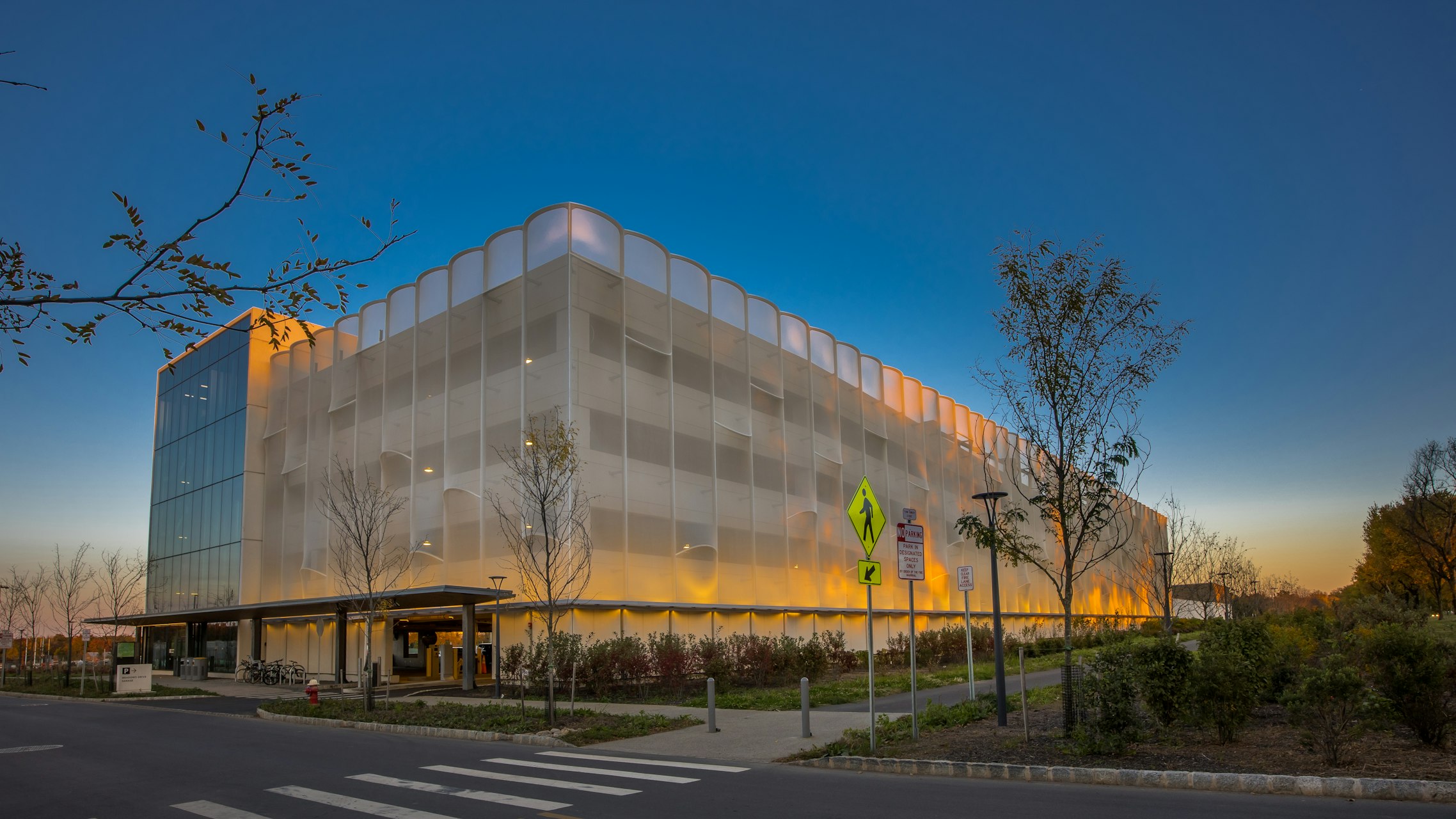An opaque PTFE ventilated fiberglass mesh with semi-circled curved rods that stick out, creating a three dimensional surface on the facade.