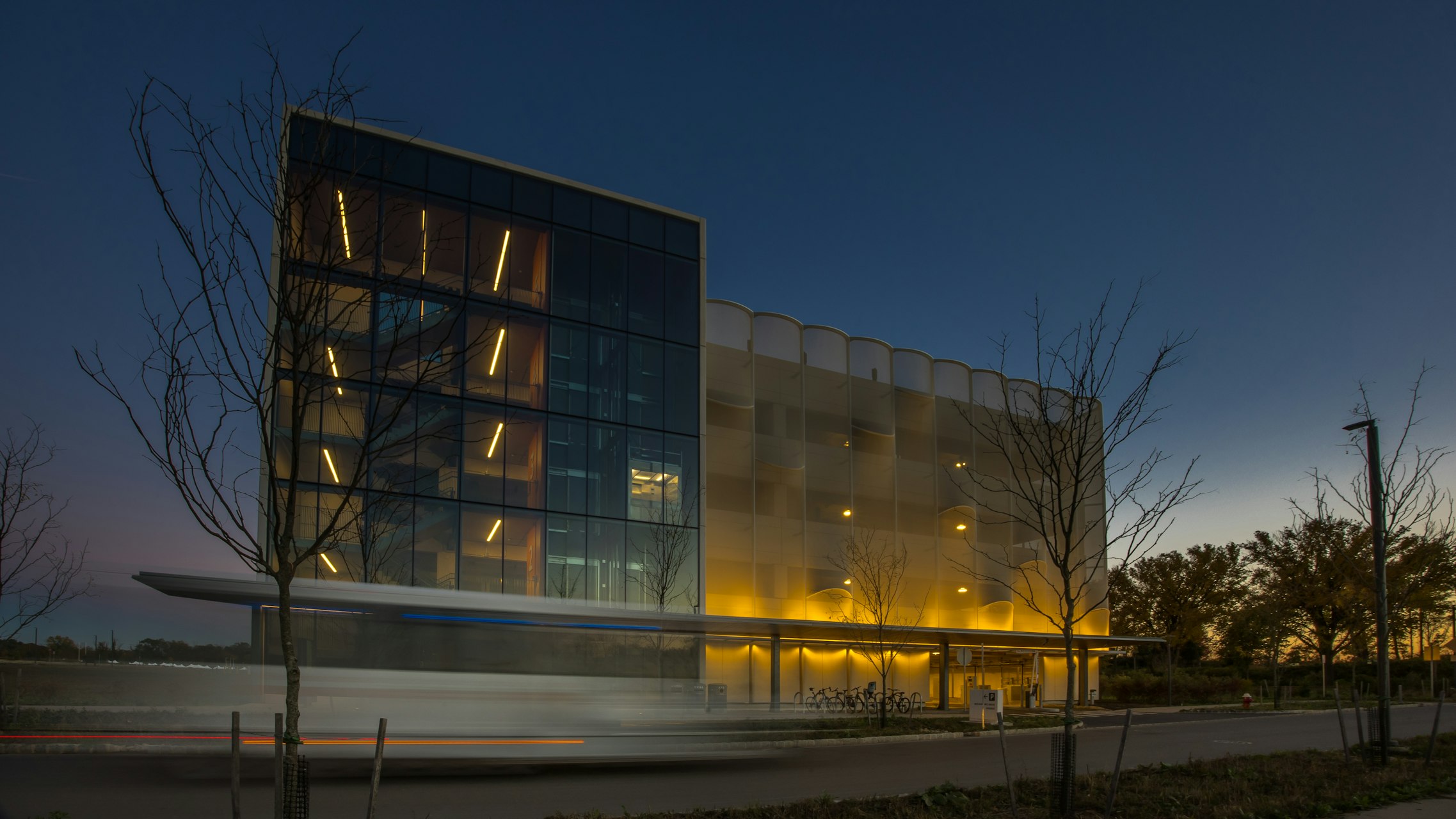 A view of the facade lit up at night.