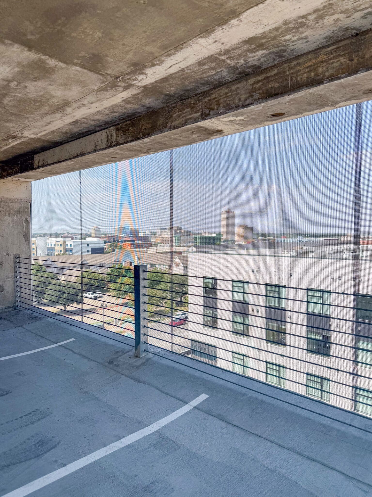 A view from inside the parking garage looking out through the facade.
