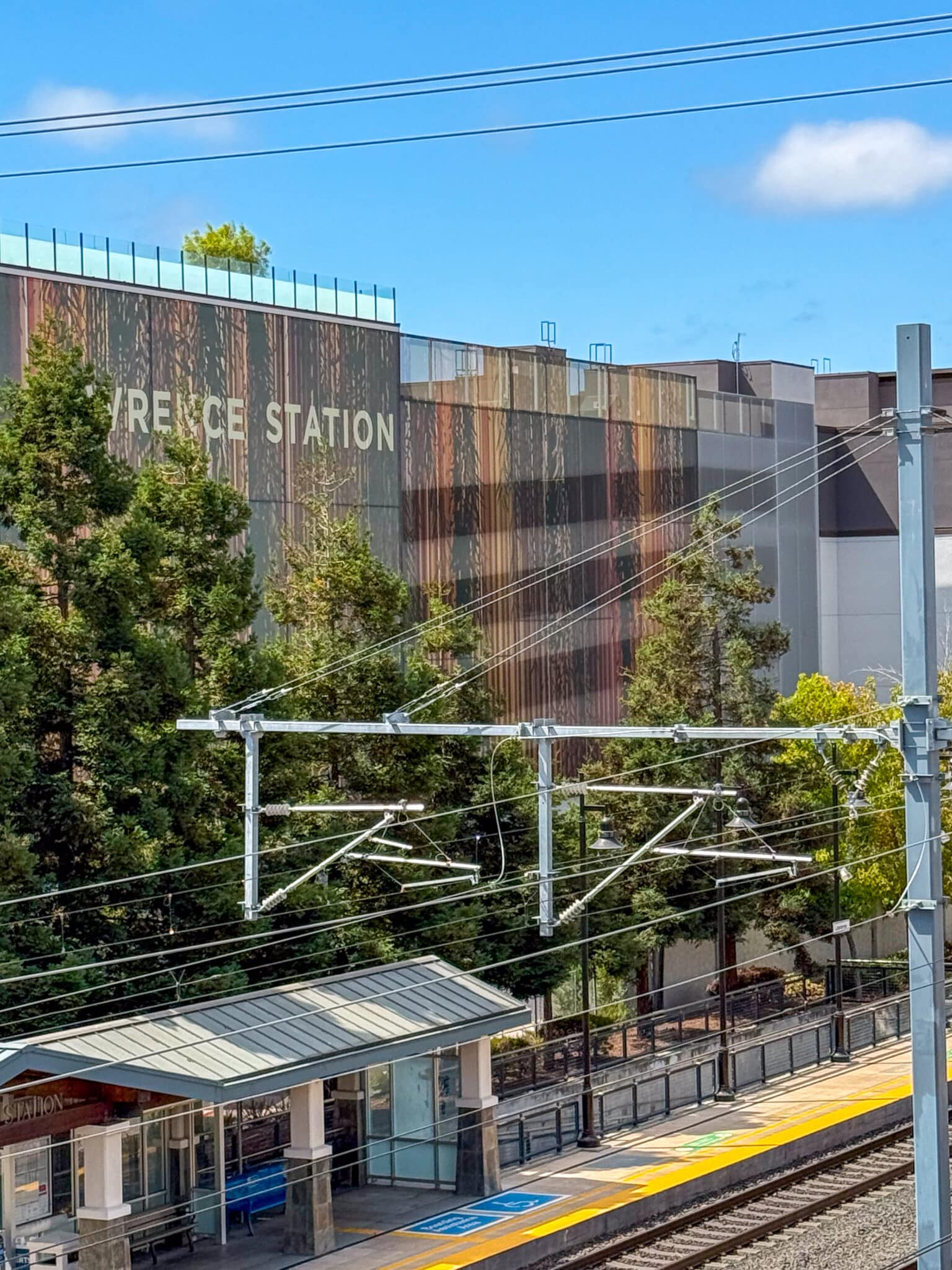 A wide view of the area that shows the parking structure and the facade in context with the transit line..
