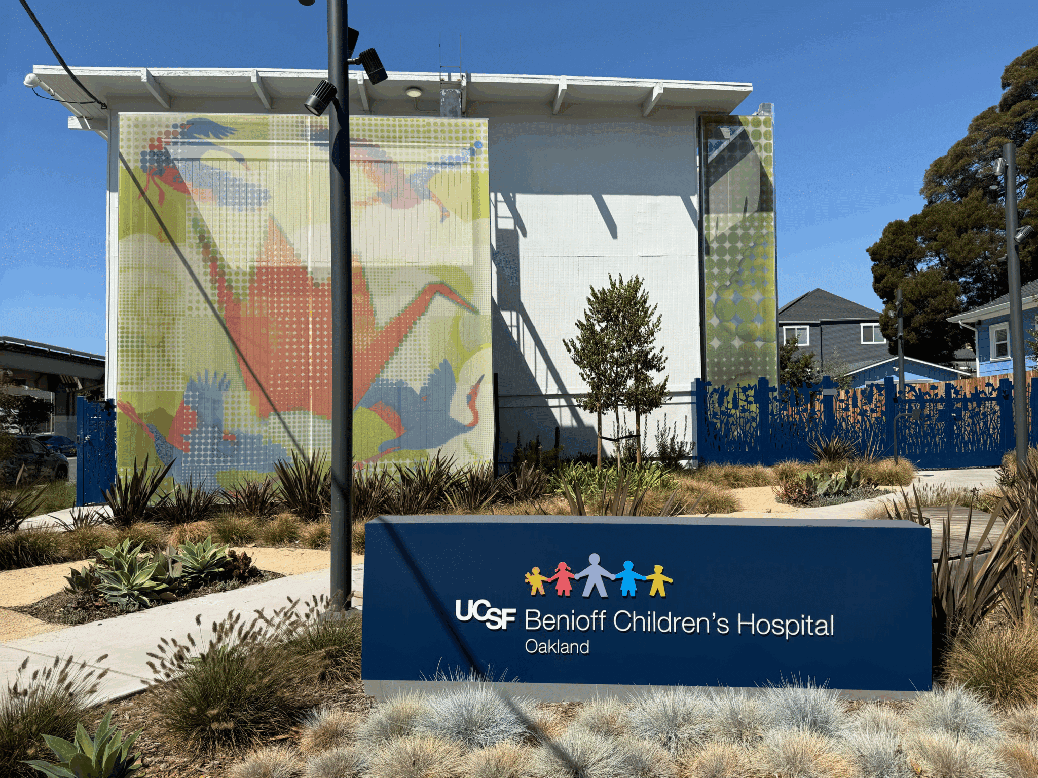 A pointellism graphic facade that features iconography of birds and an oragami swan.