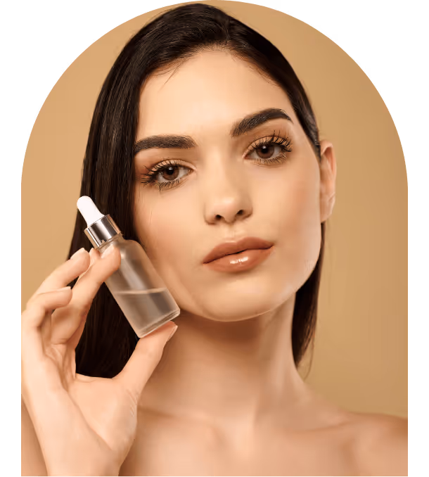 Woman with clear skin holding a small frosted glass dropper bottle near her face against a beige background.