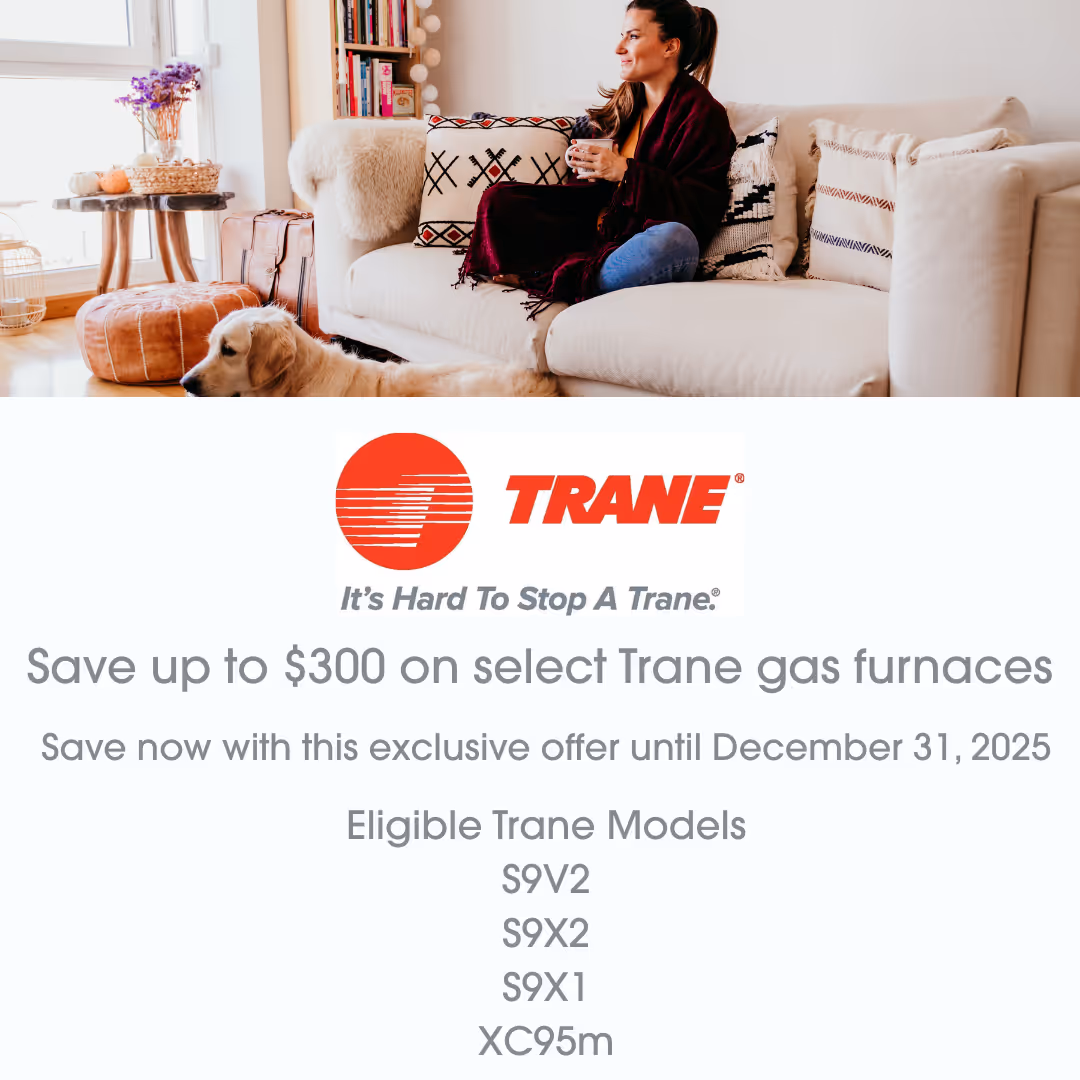 Woman sitting on a white couch holding a cup with a golden retriever lying on the floor in a cozy living room, above a Trane gas furnace rebate offer with eligible models listed.
