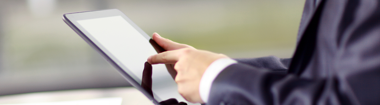 Person in business suit using a touchscreen tablet device.