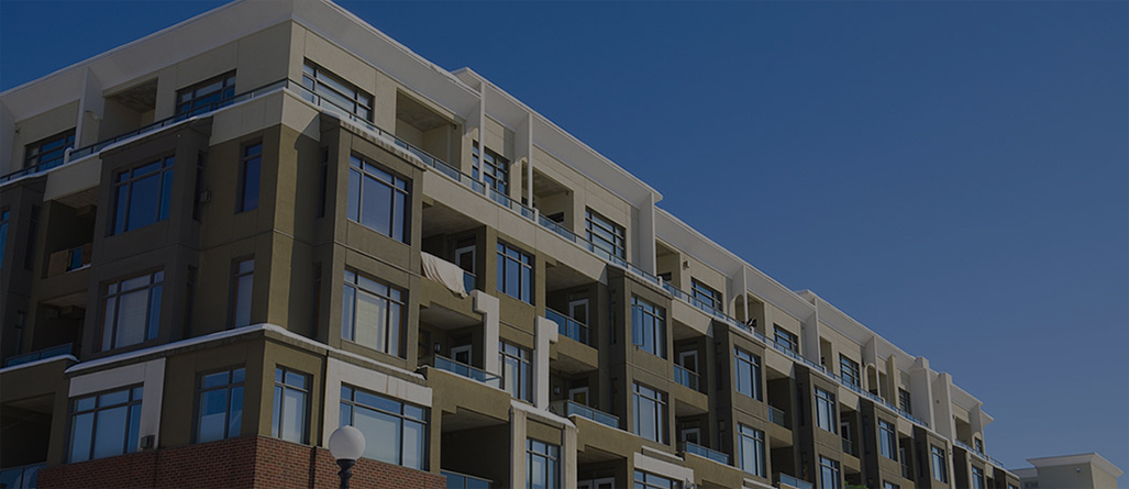 Modern multi-story apartment building under a clear blue sky.