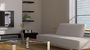 Modern living room with a white sofa, glass coffee table, wall-mounted TV, and shelves with decorative items.