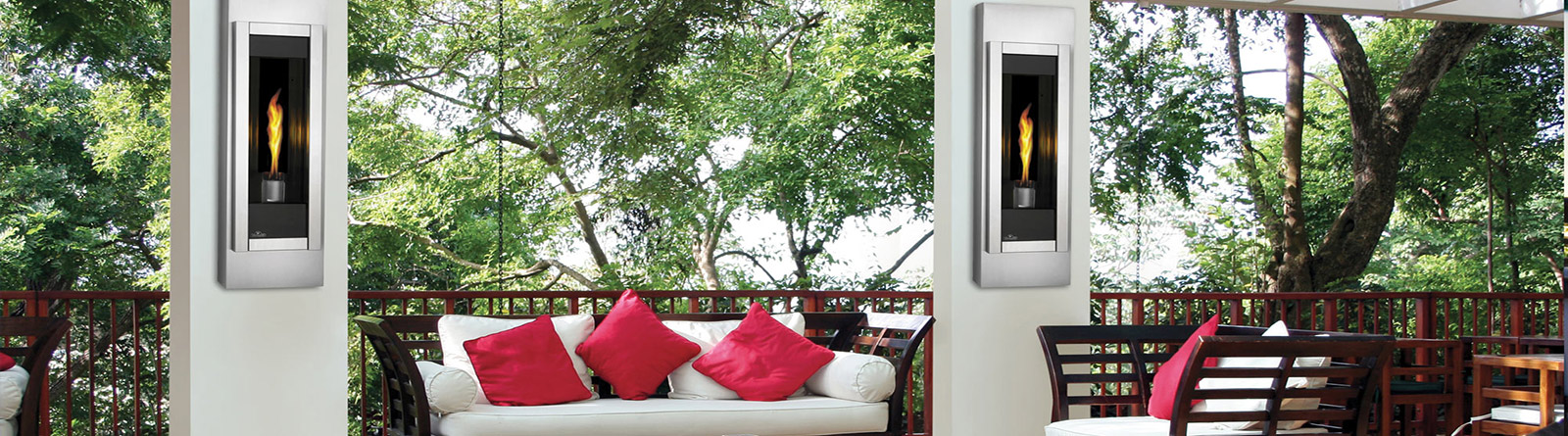 Outdoor seating area with white cushioned chairs, red pillows, wooden railing, and two wall-mounted modern stainless steel fireplaces.