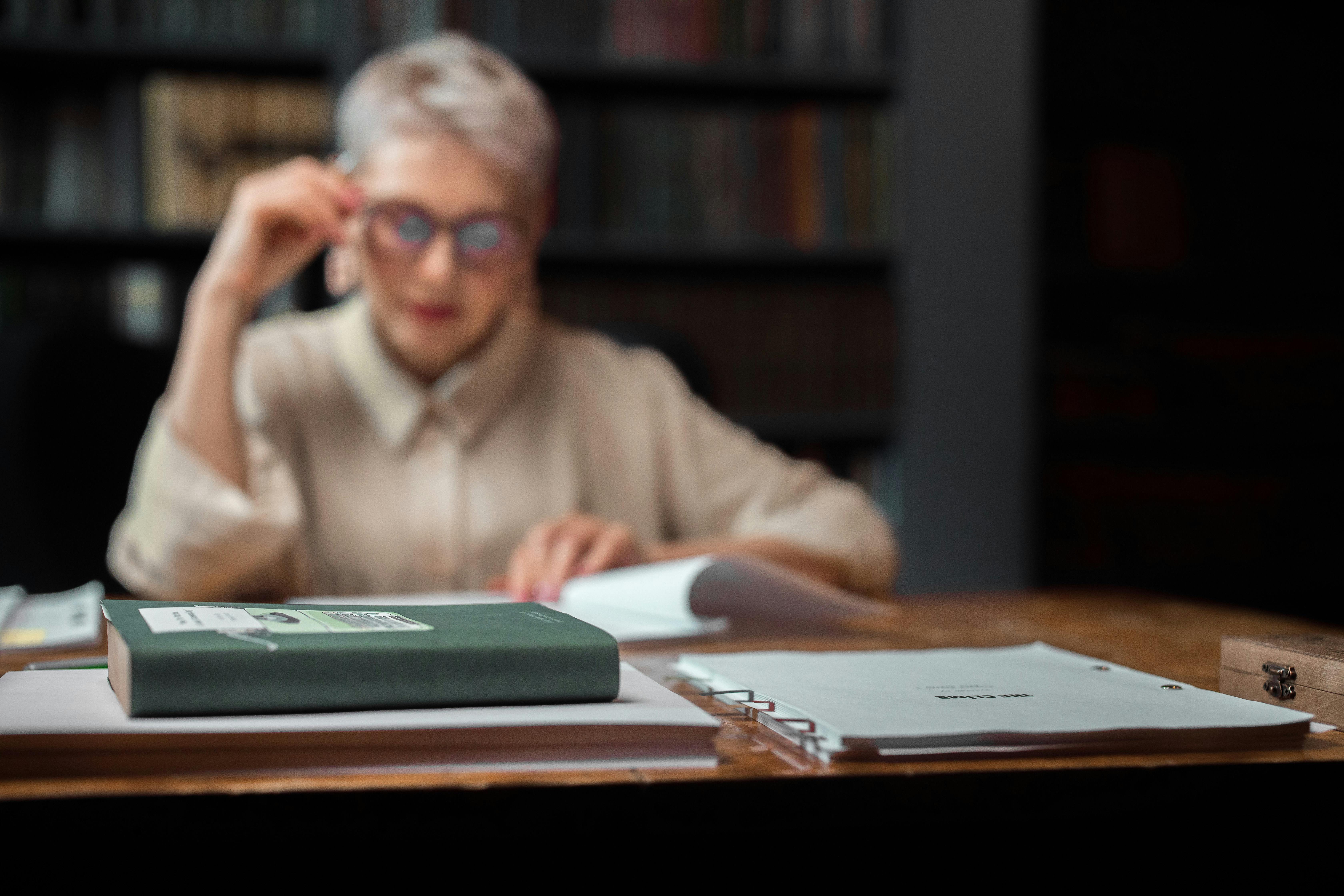 Mujer leyendo unos documentos para darse de baja de su seguro de decesos