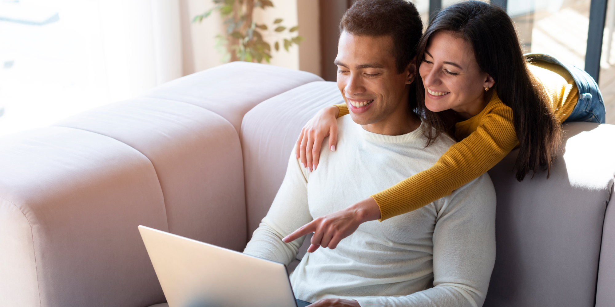 Pareja feliz utilizando el Panel de Invitados Weddeb en su laptop para organizar la lista de su boda sin estrés.