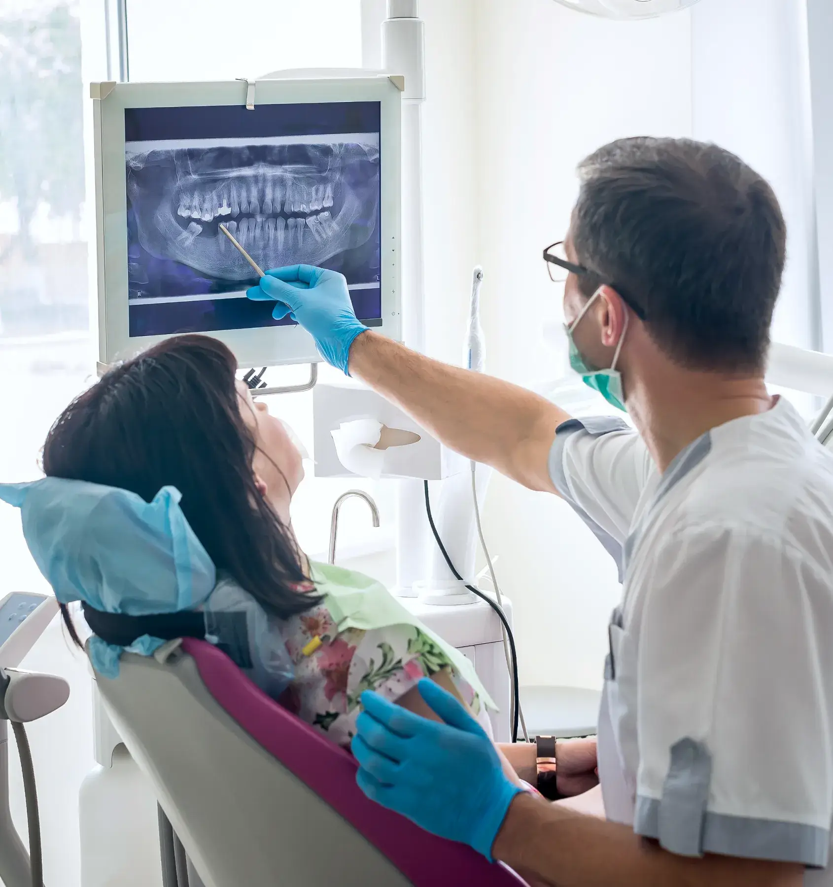 a dentist examining a patient's teeth in a dental office