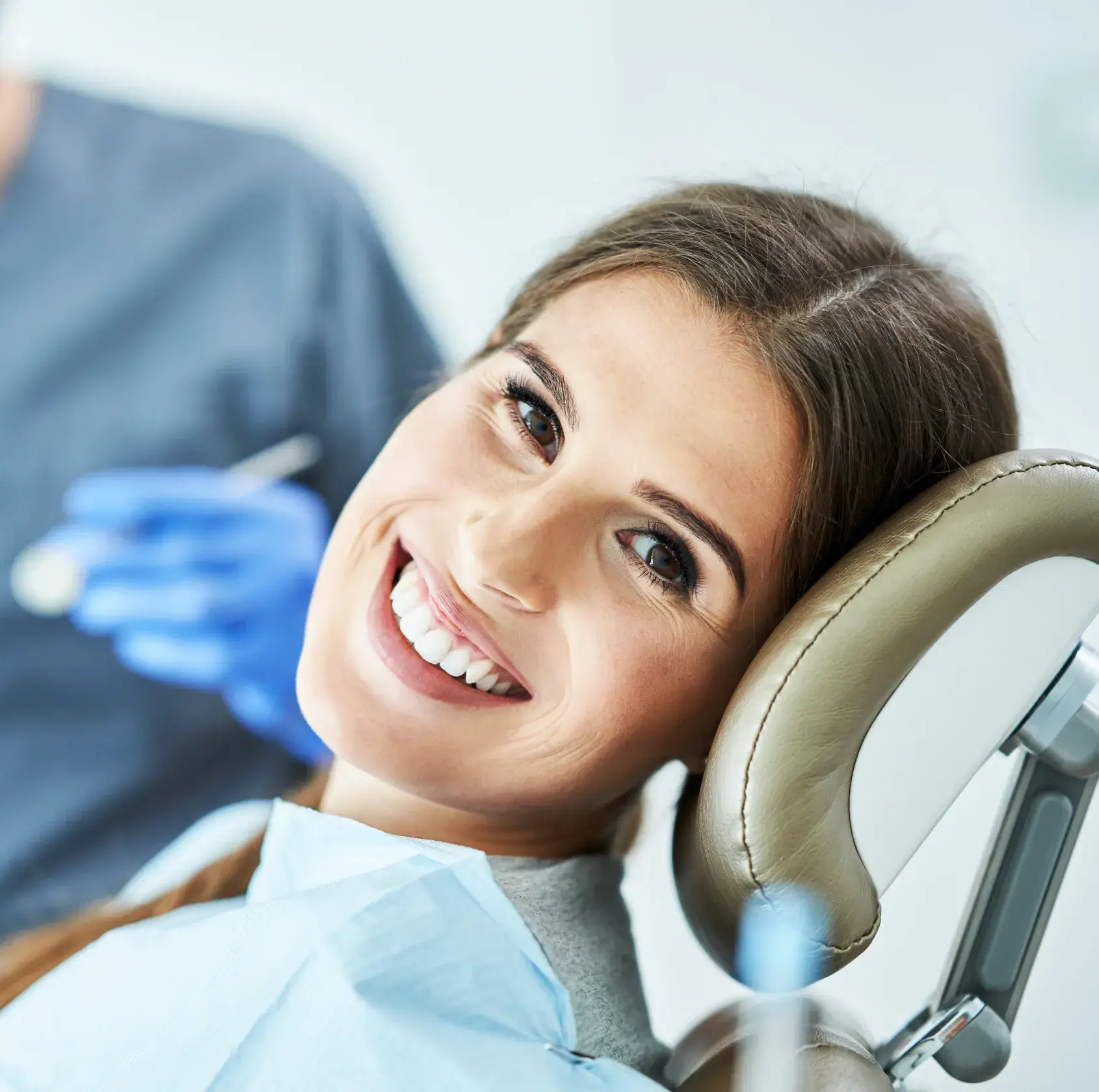 a woman sitting in a dentist chair smiling