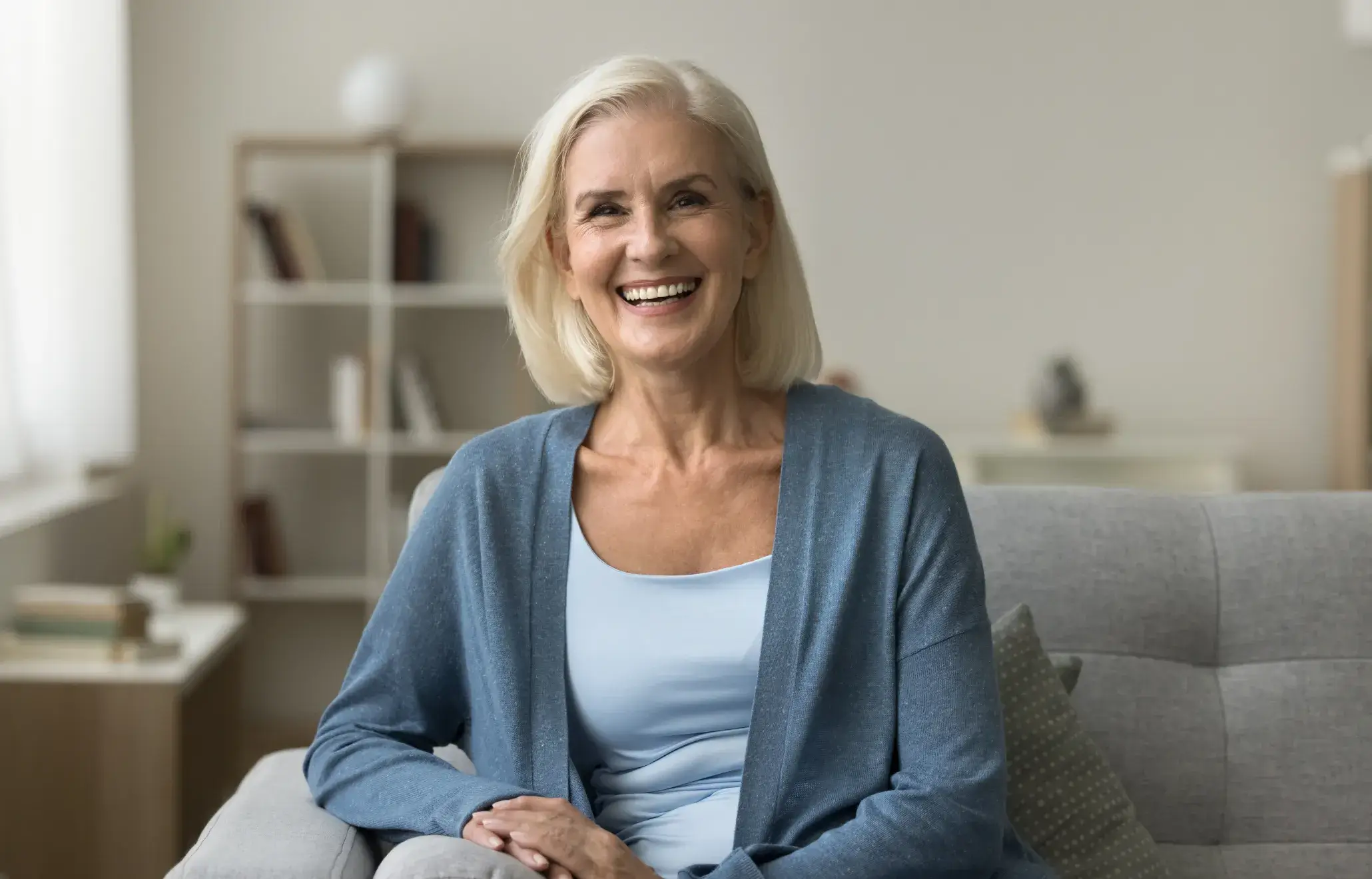 a woman sitting on a couch smiling at the camera