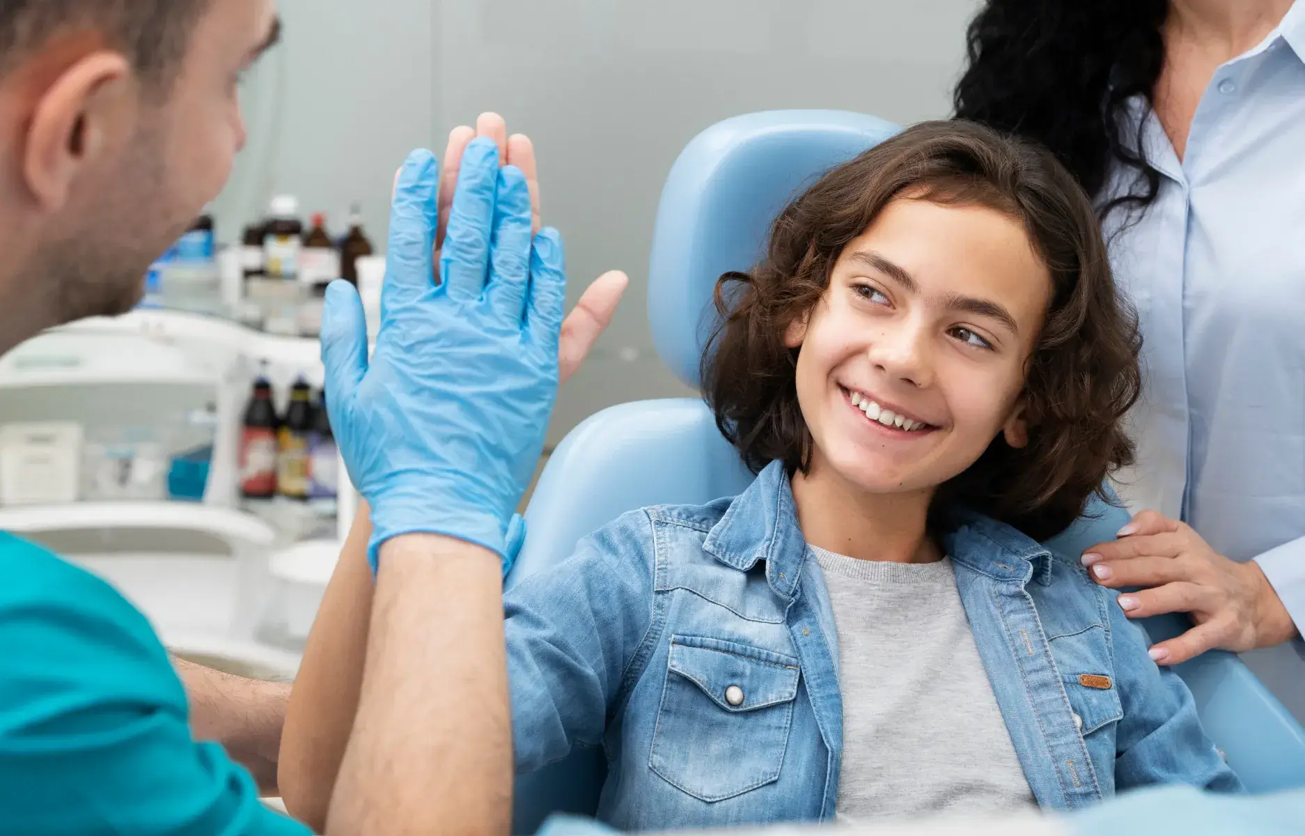 a young girl getting her teeth checked by a dentist