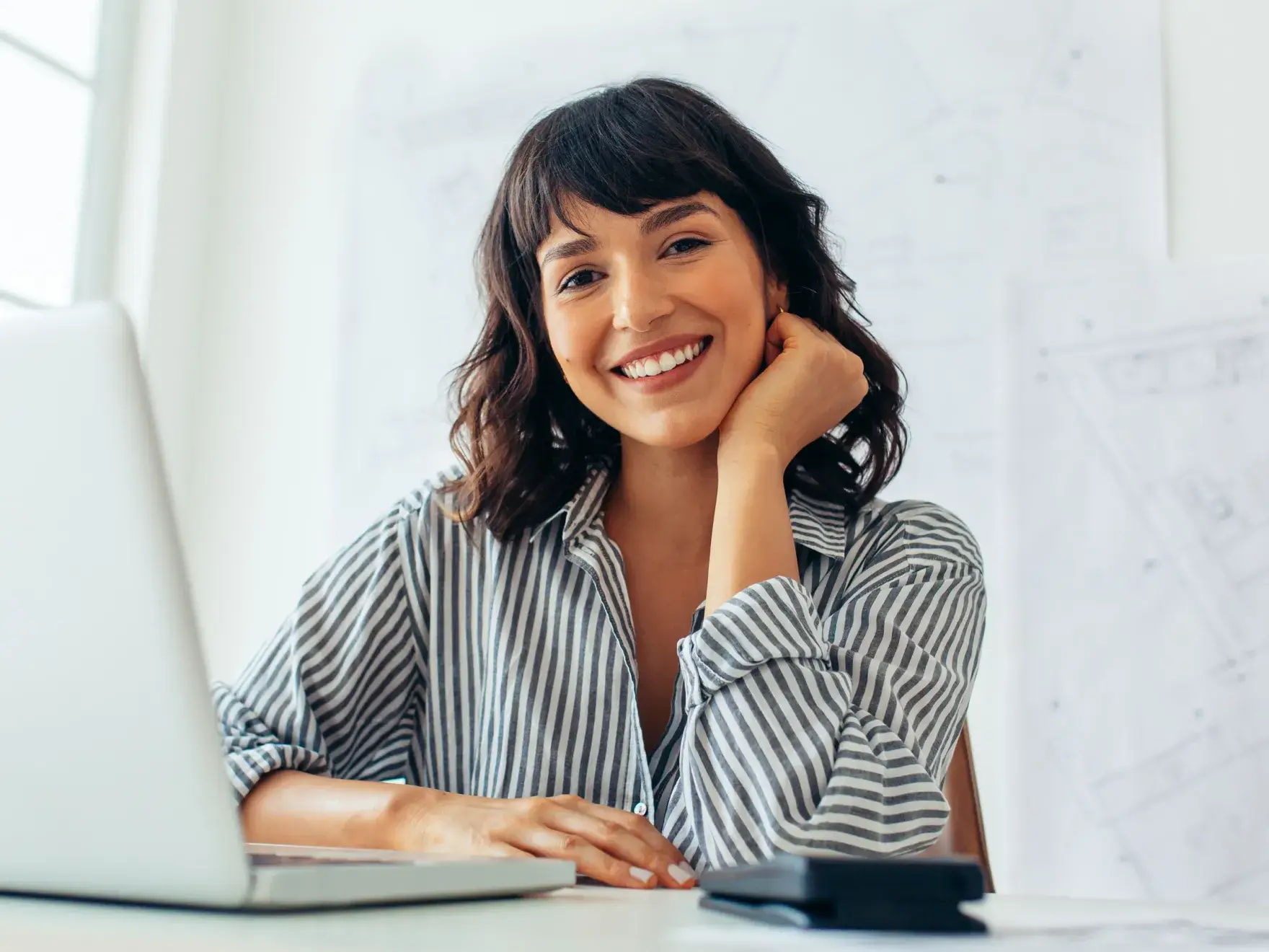 a woman sitting in front of a laptop computer