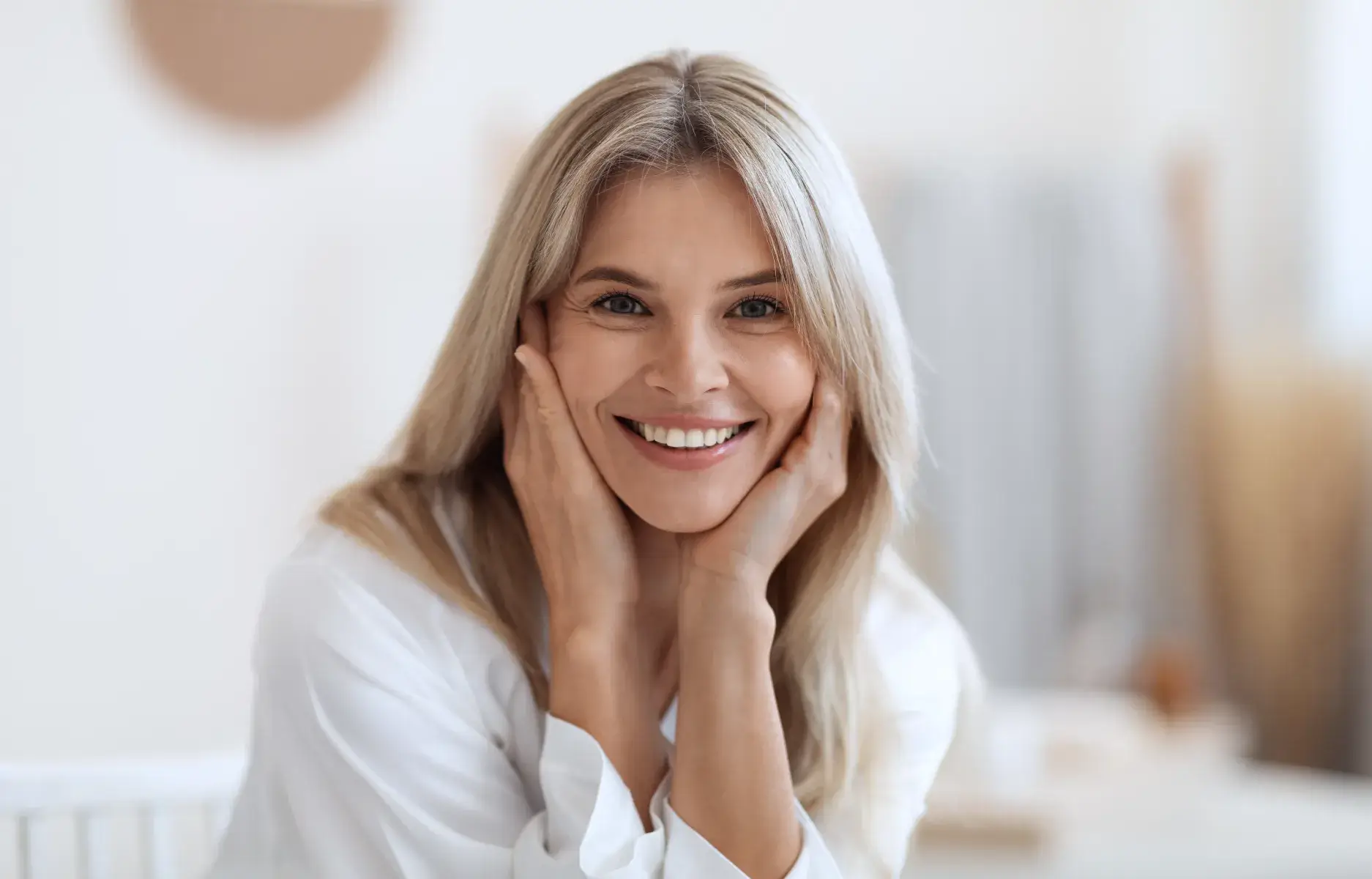 a woman with blonde hair smiling at the camera