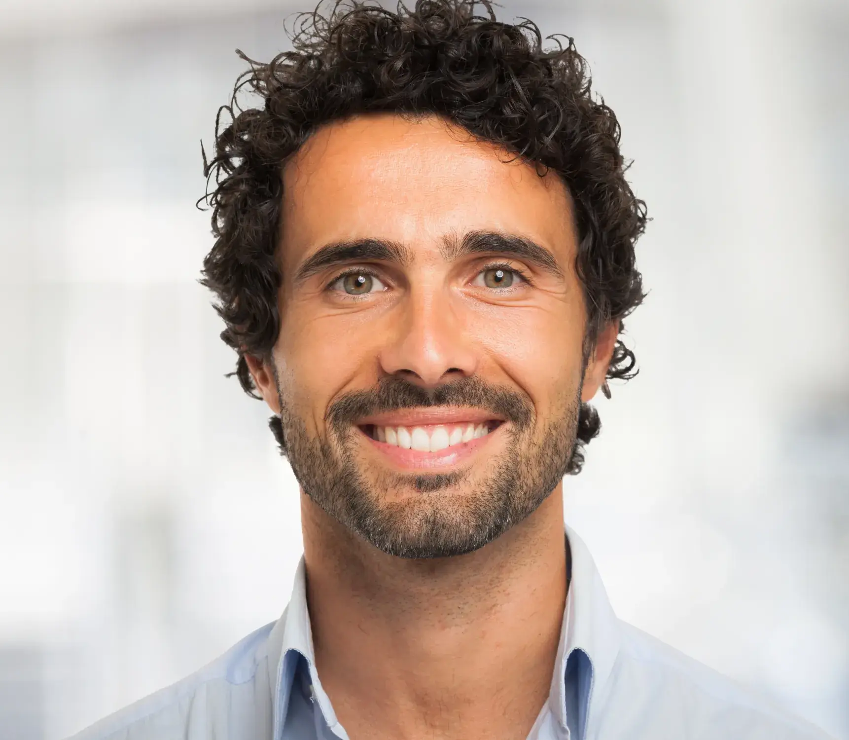 a man with curly hair and a blue shirt