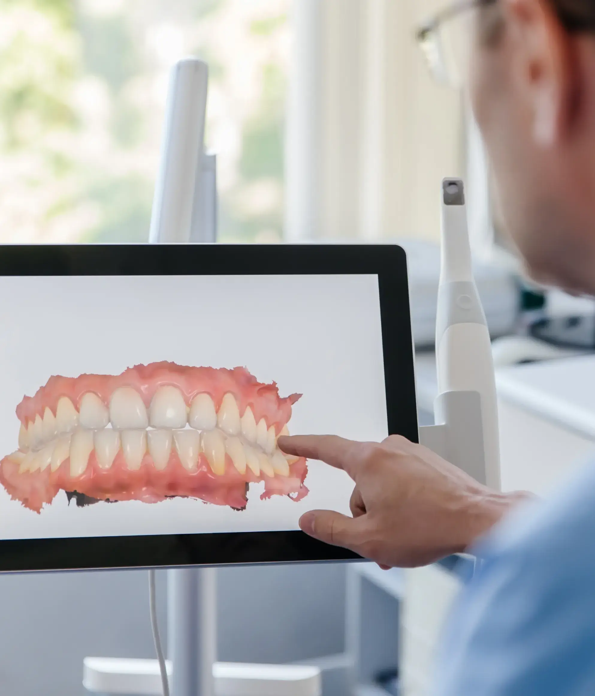 a man pointing to a picture of a tooth on a computer screen