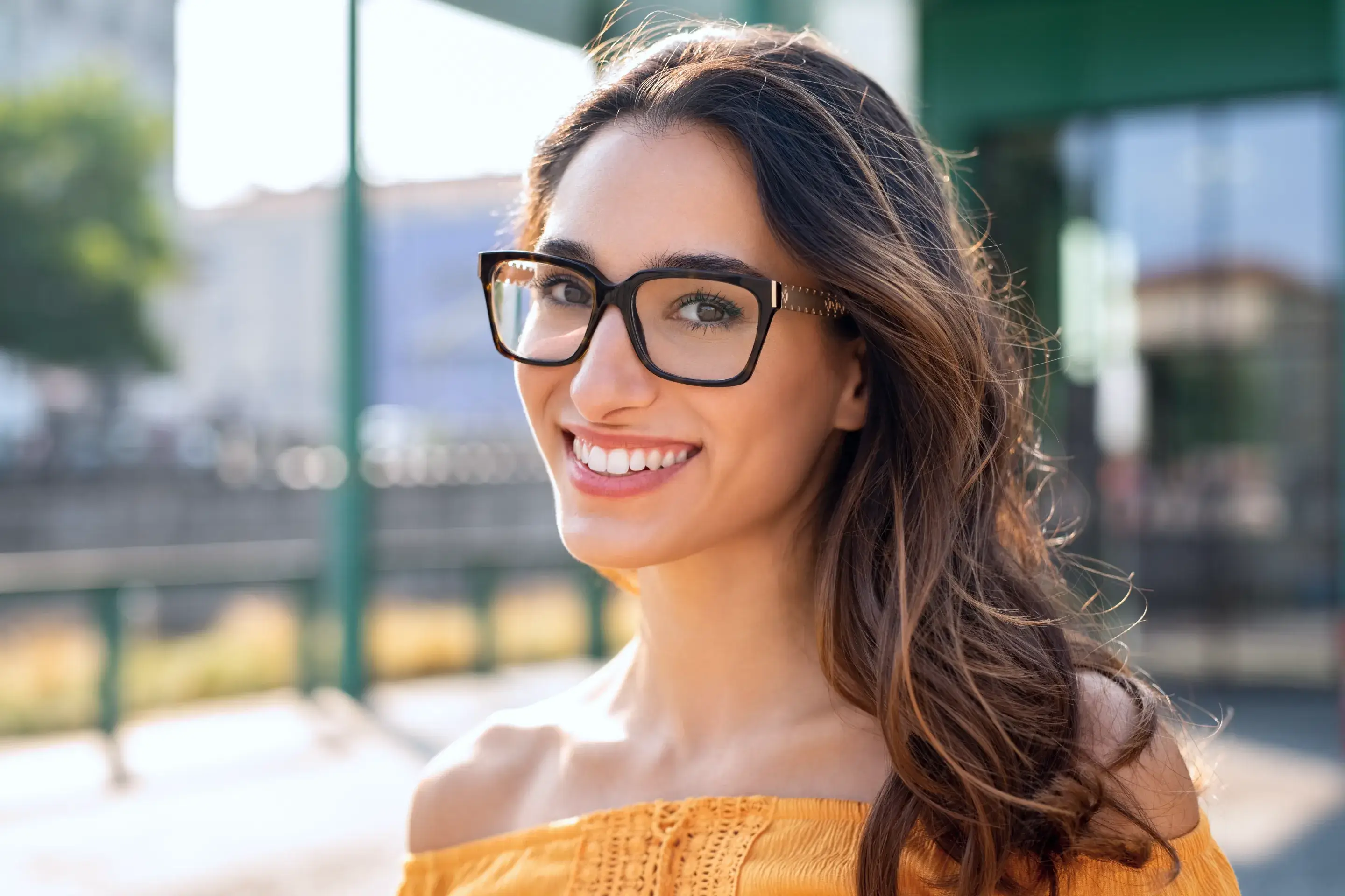 a woman wearing glasses and smiling for the camera