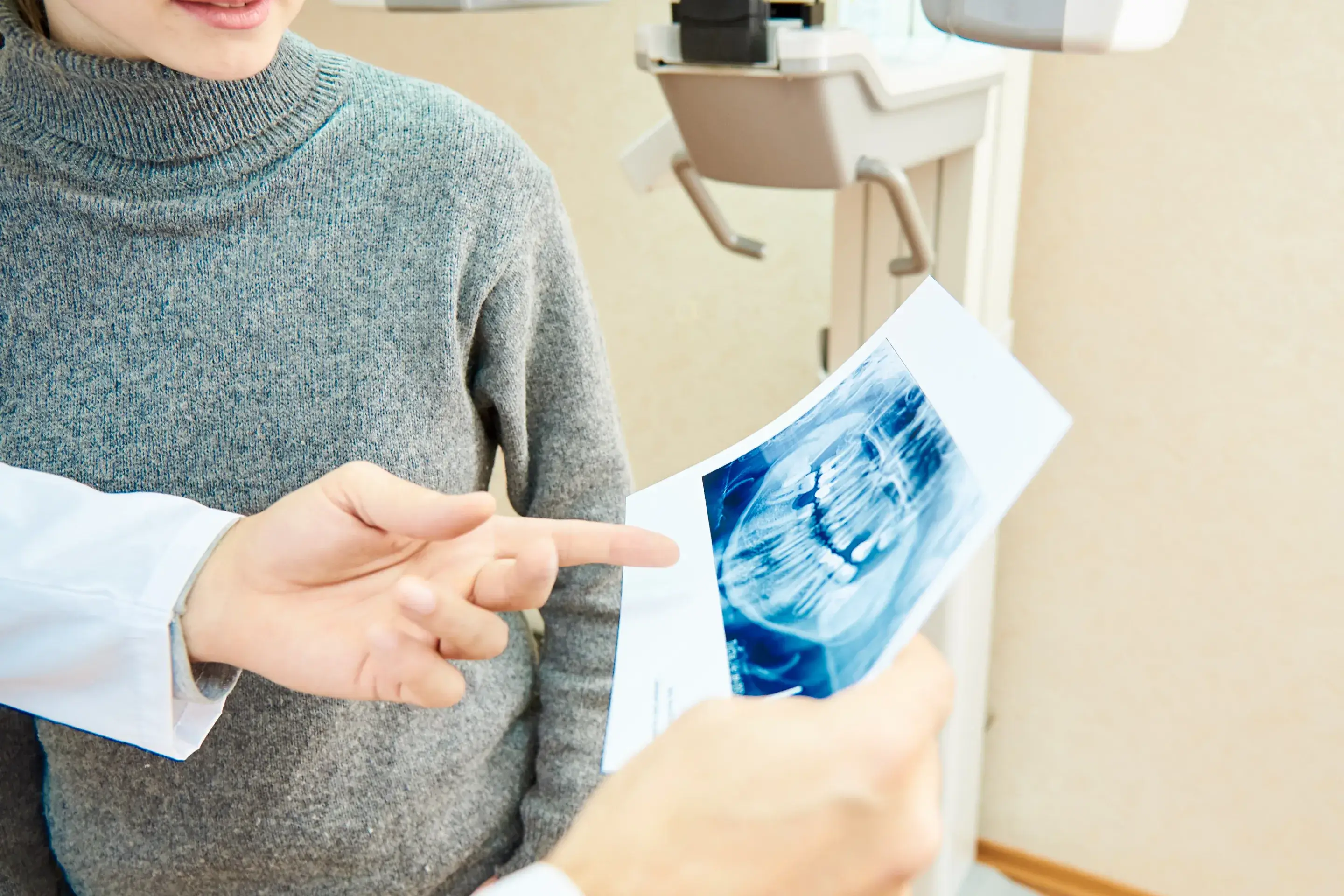 a person pointing at a picture of a tooth