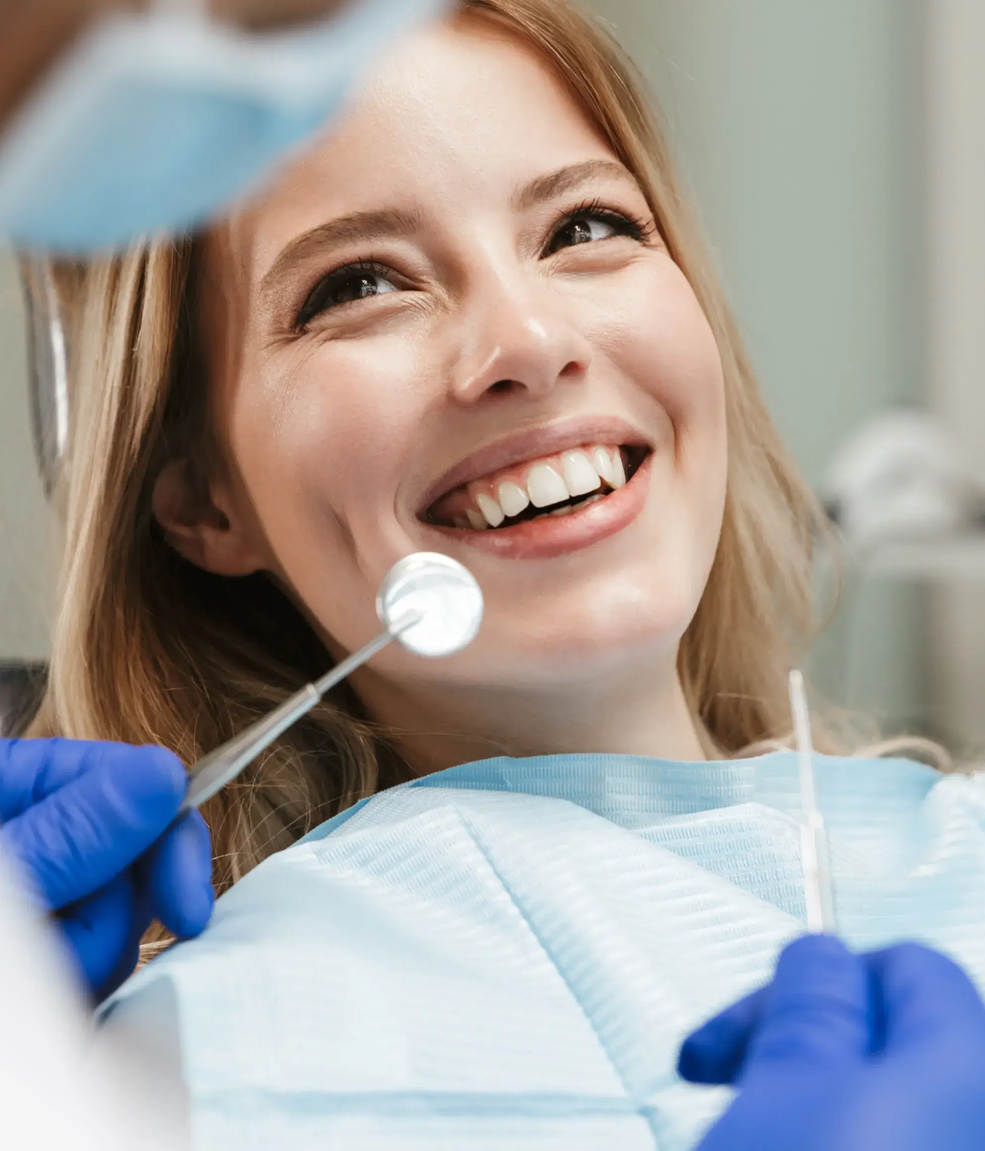a woman smiling while holding a toothbrush in her mouth