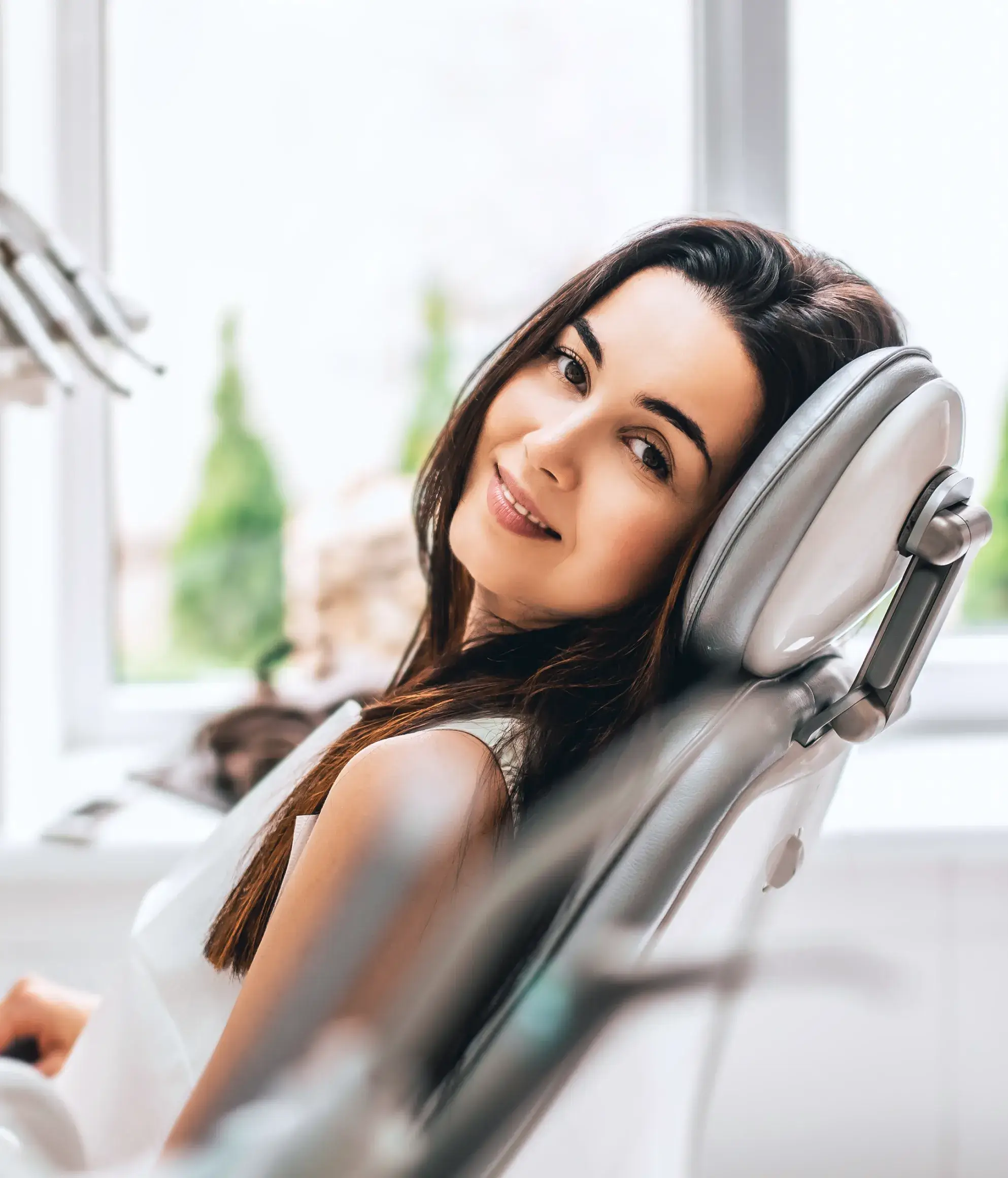a woman sitting in a dentist chair smiling