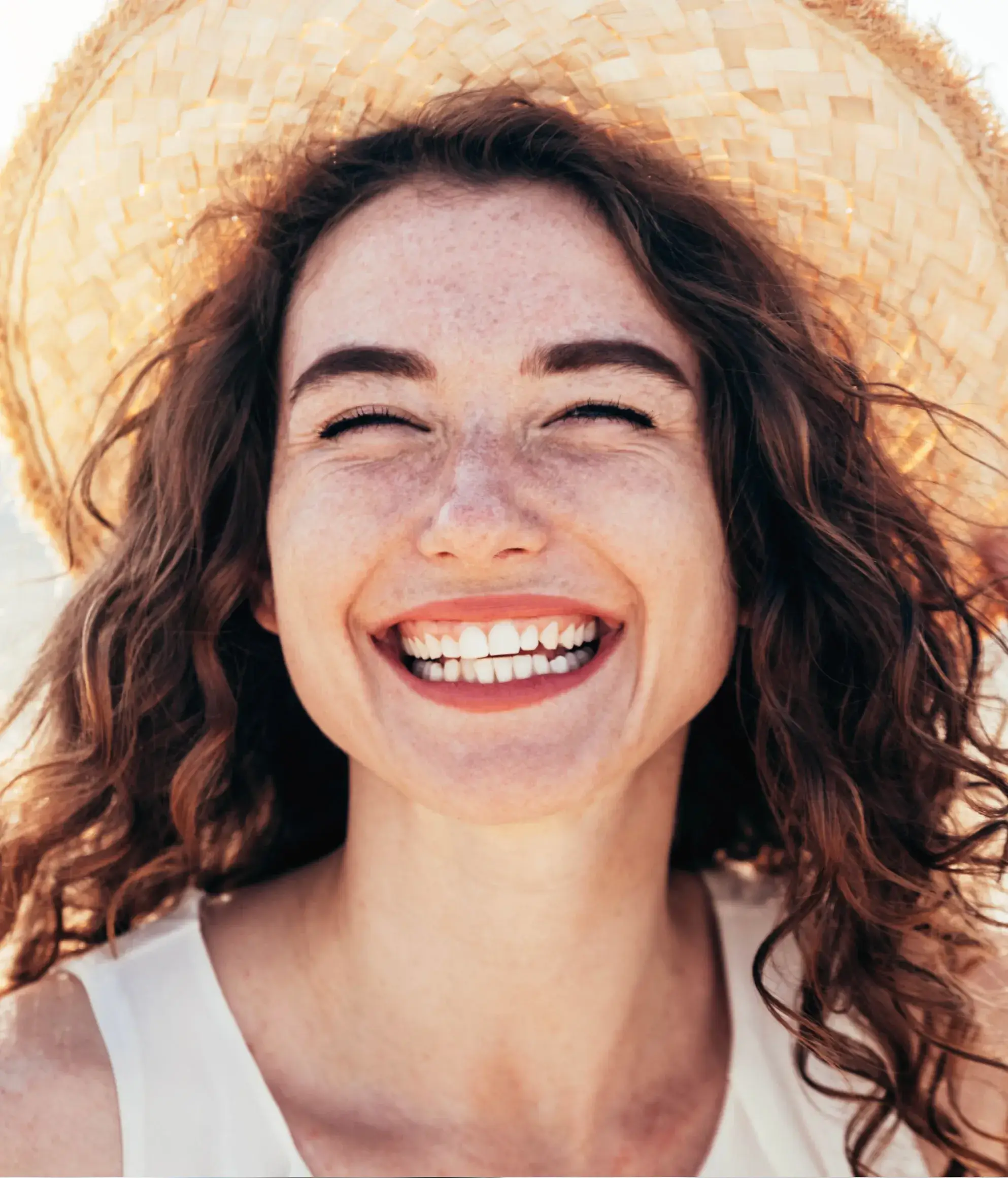 a woman wearing a straw hat and smiling
