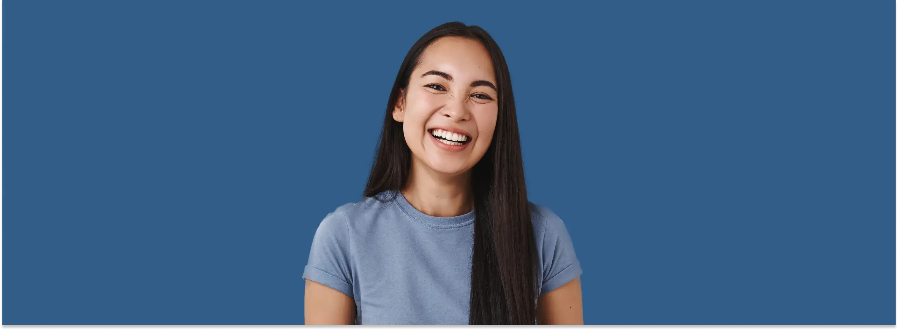 a woman with long hair smiling and wearing a blue shirt
