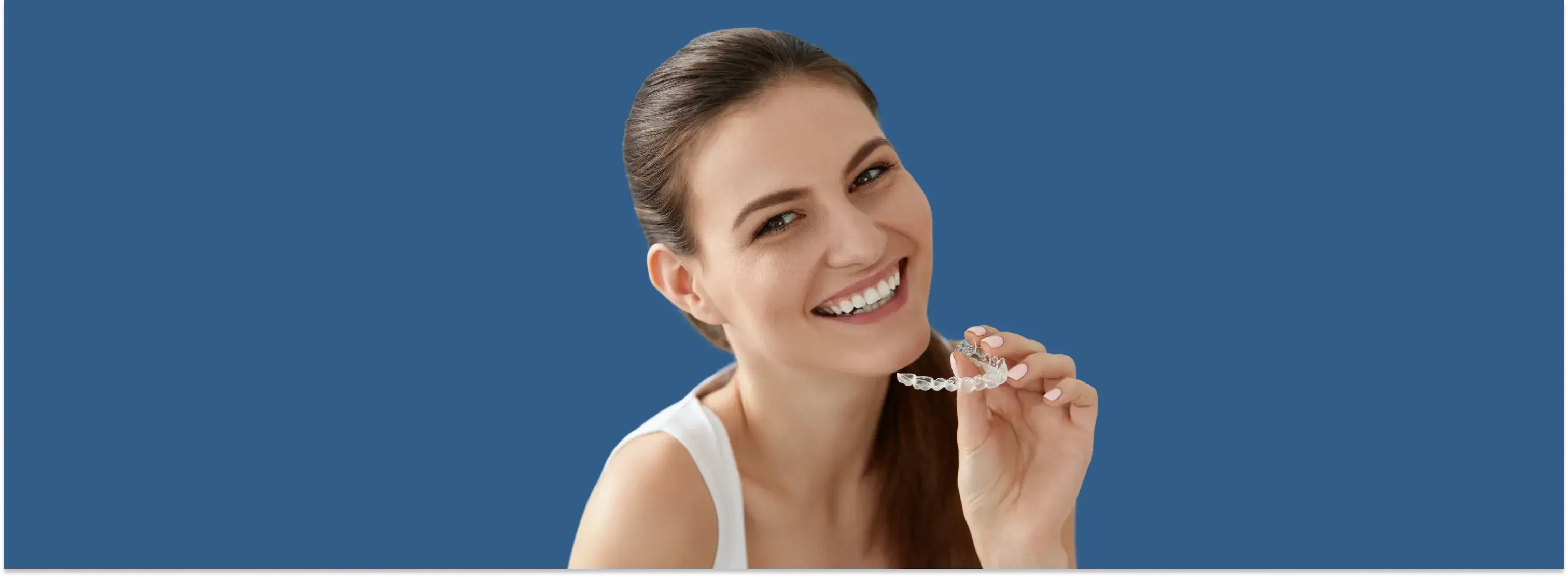 a woman smiles while holding a toothbrush in her hand