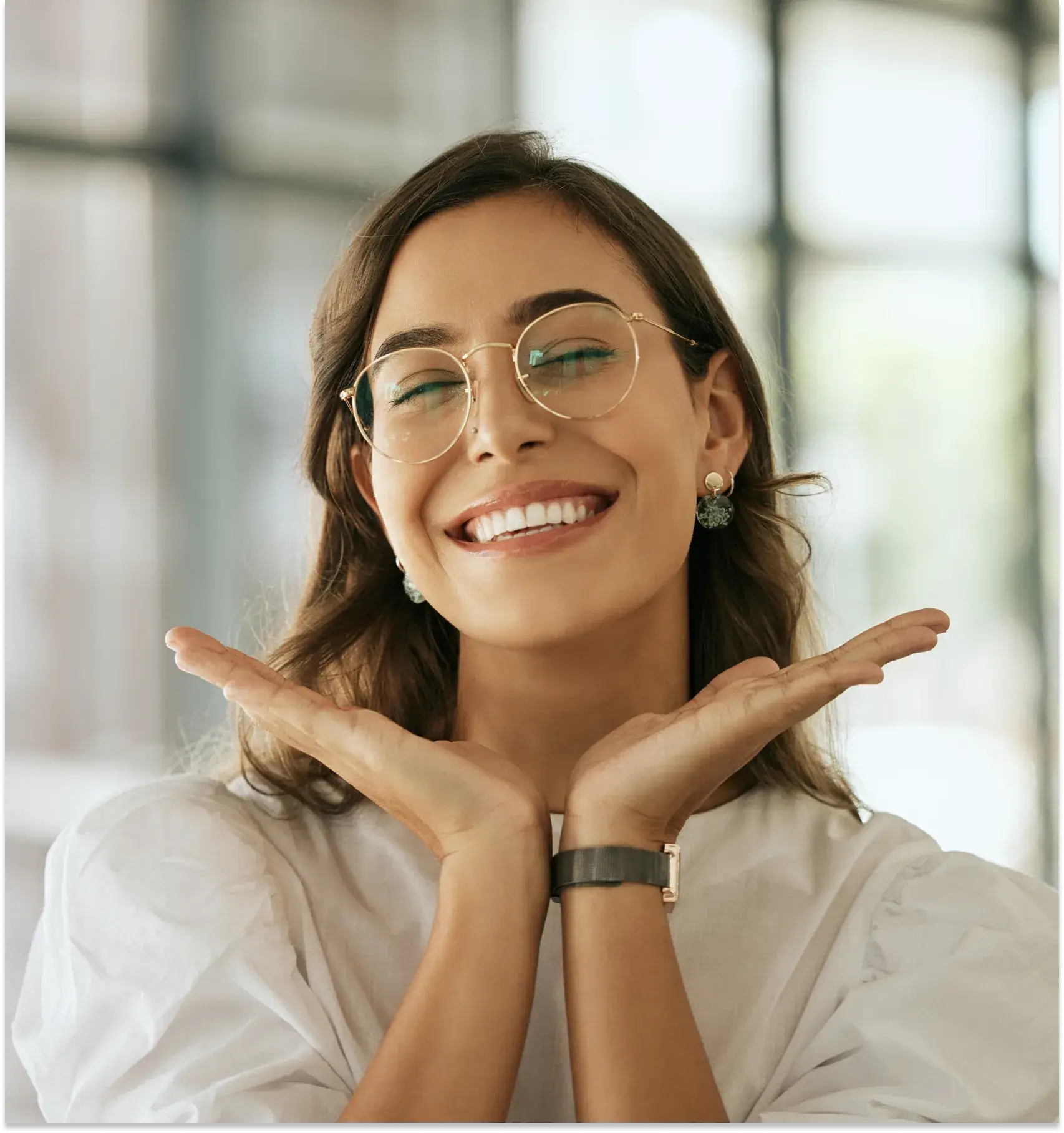 a woman wearing glasses making a gesture with her hands