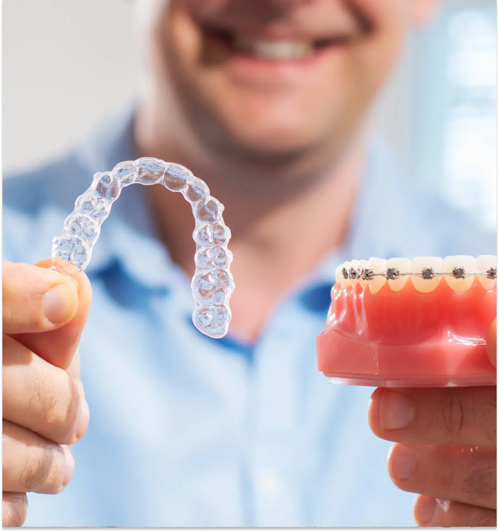 a man holding a fake tooth and a fake toothbrush