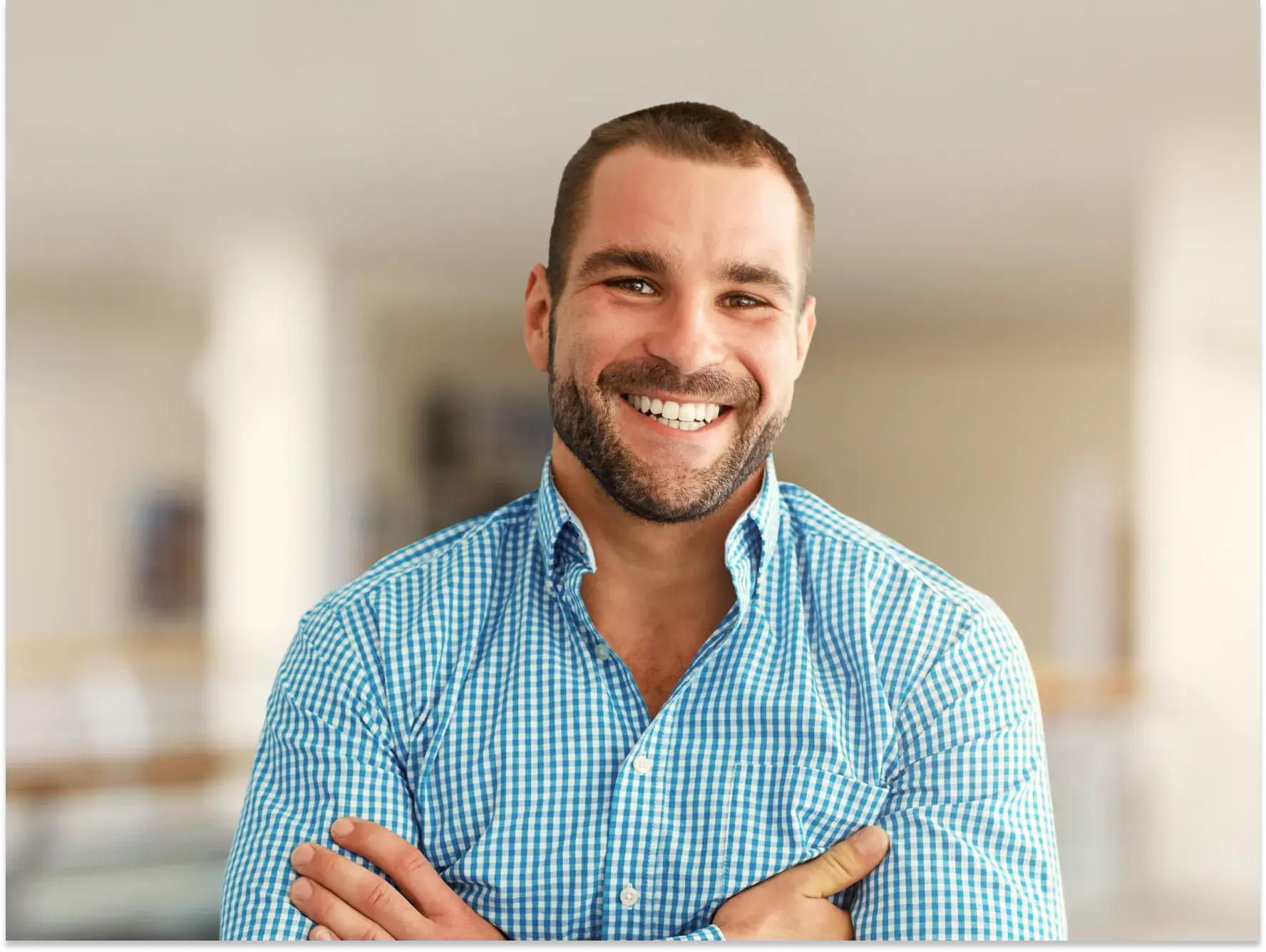 a smiling man with his arms crossed
