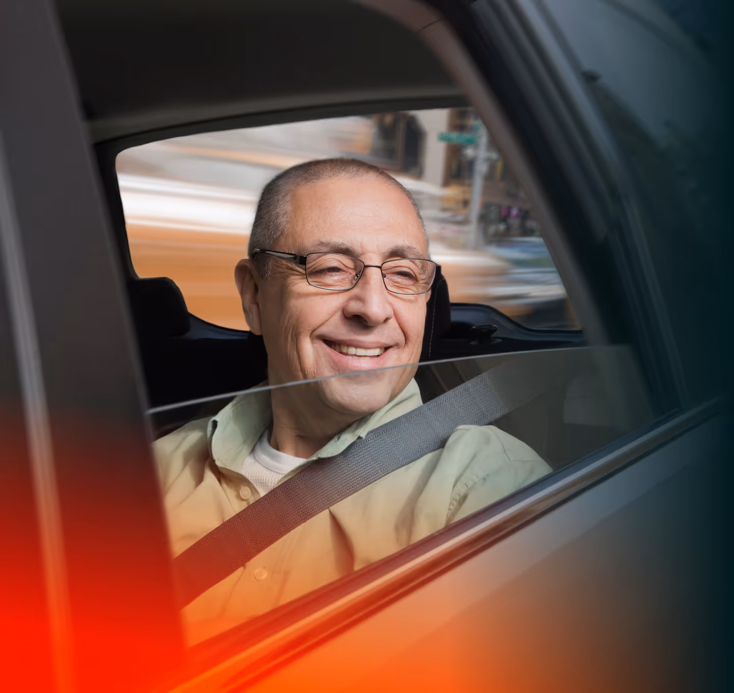 Smiling elderly man wearing glasses and a seatbelt, sitting in the backseat of a car.