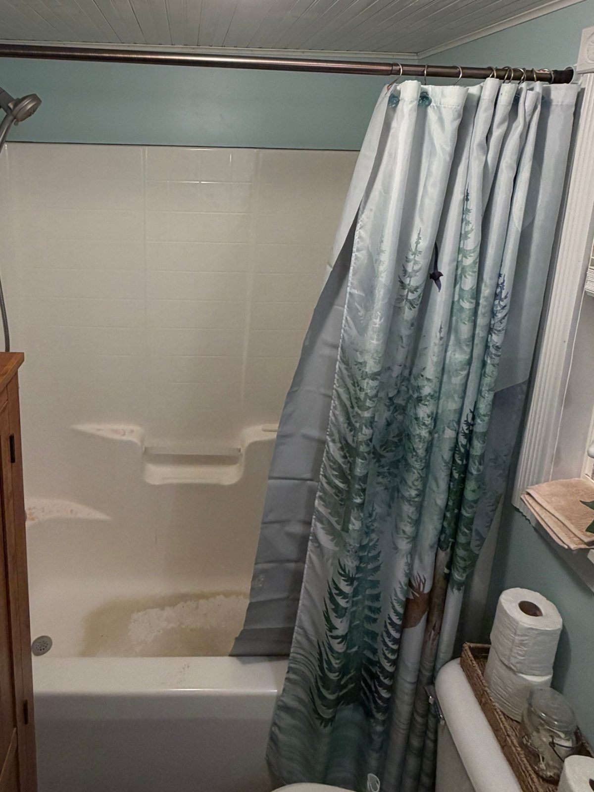 Older tub with a white tile surround and a shower curtain before the tub-to-shower conversion in Hilham, TN