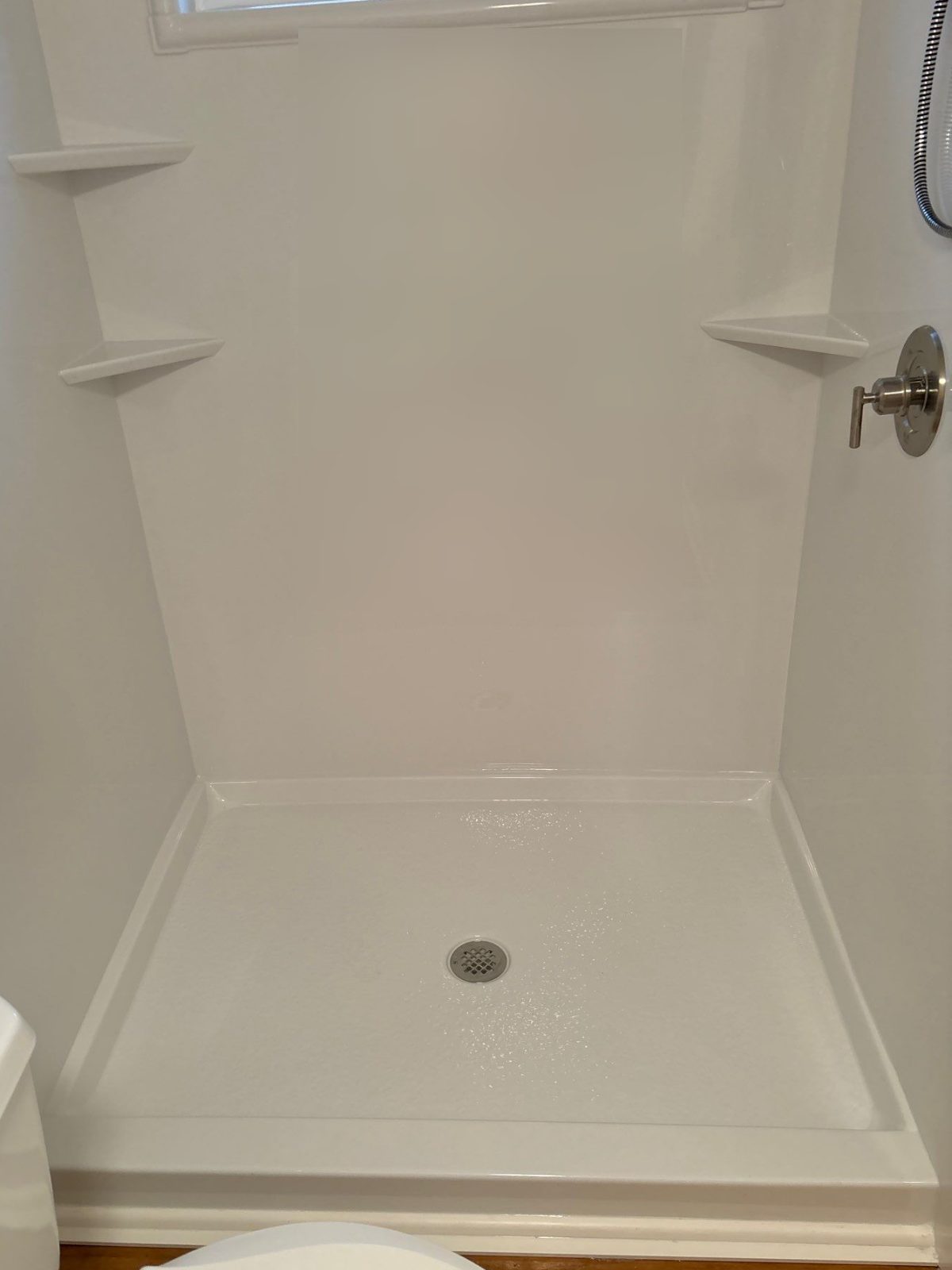Same Overton County bathroom after conversion to a bright white walk-in shower with corner shelves and brushed nickel fixtures