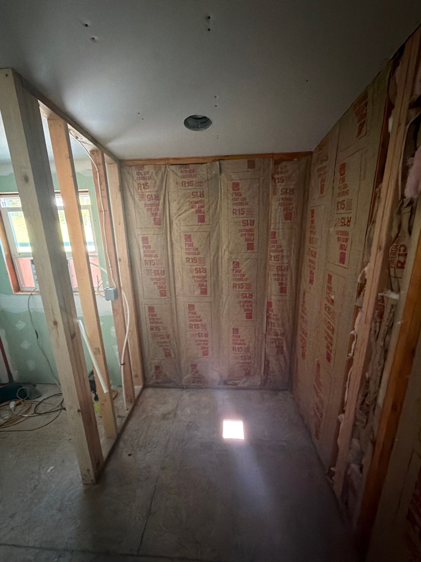 Framed, insulated stud bay with a bare subfloor and no shower yet in a home addition, before shower installation in Gainesboro, TN