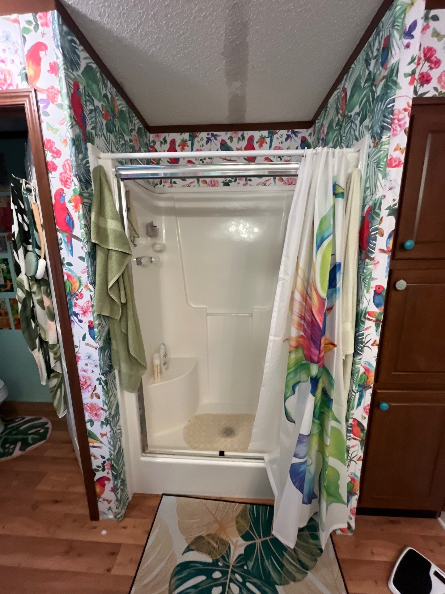 Old almond fiberglass shower stall with a molded corner seat, a framed sliding door and a fabric curtain before shower replacement in Rock Island, TN