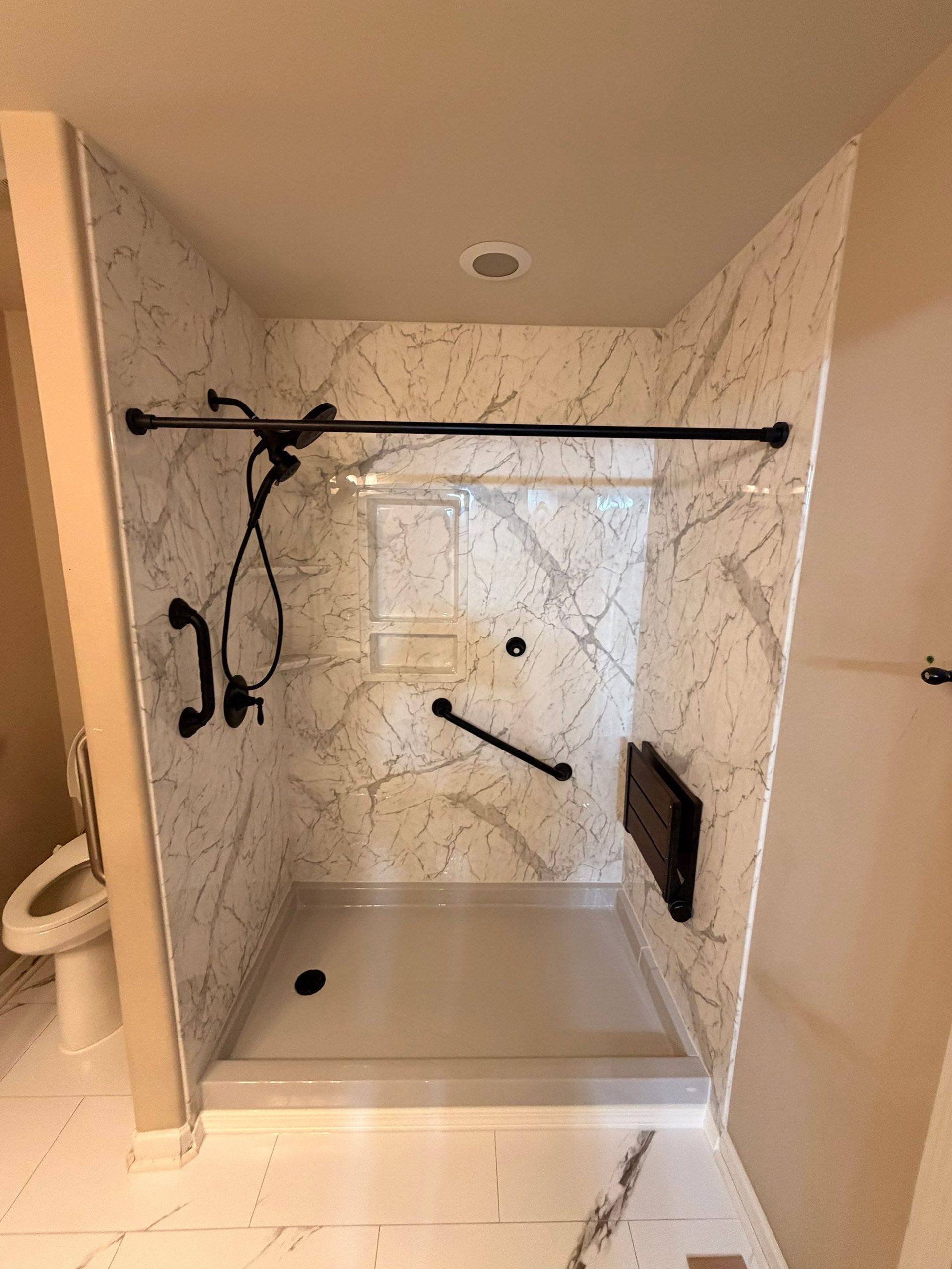 After: new shower with marble-look walls and fold-down seat