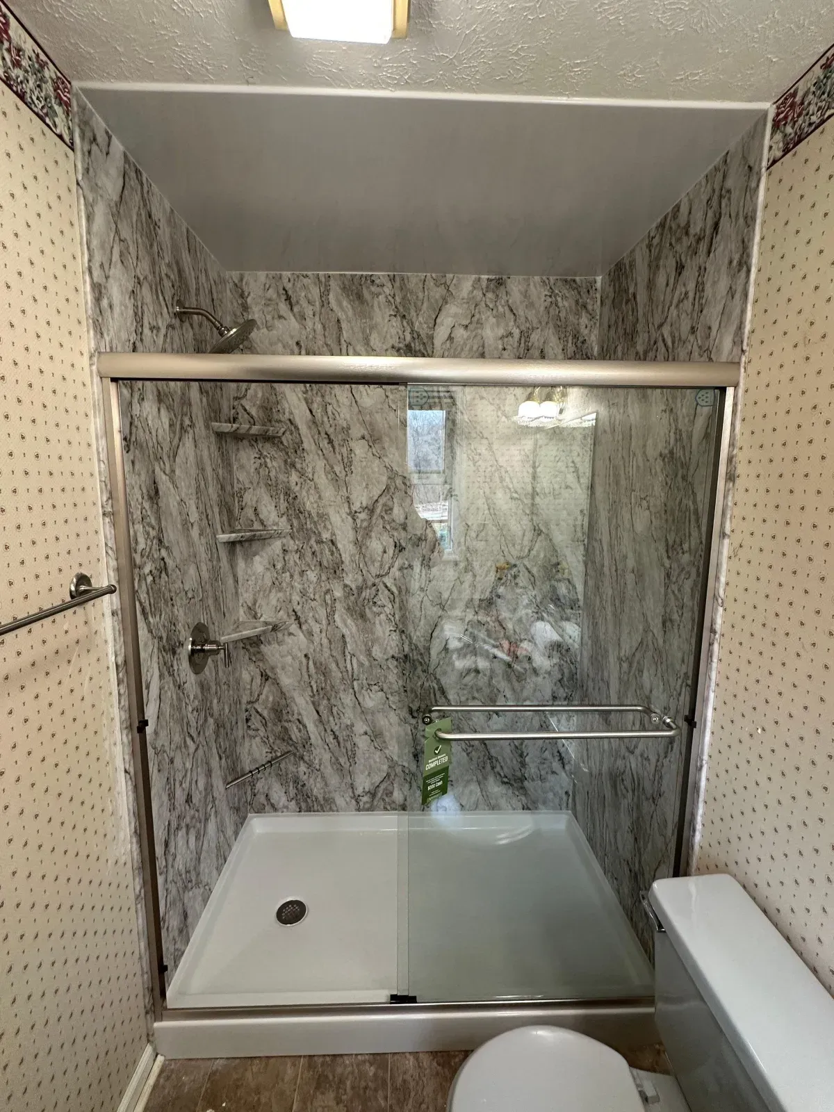 After: new shower with gray marble-look walls and glass doors