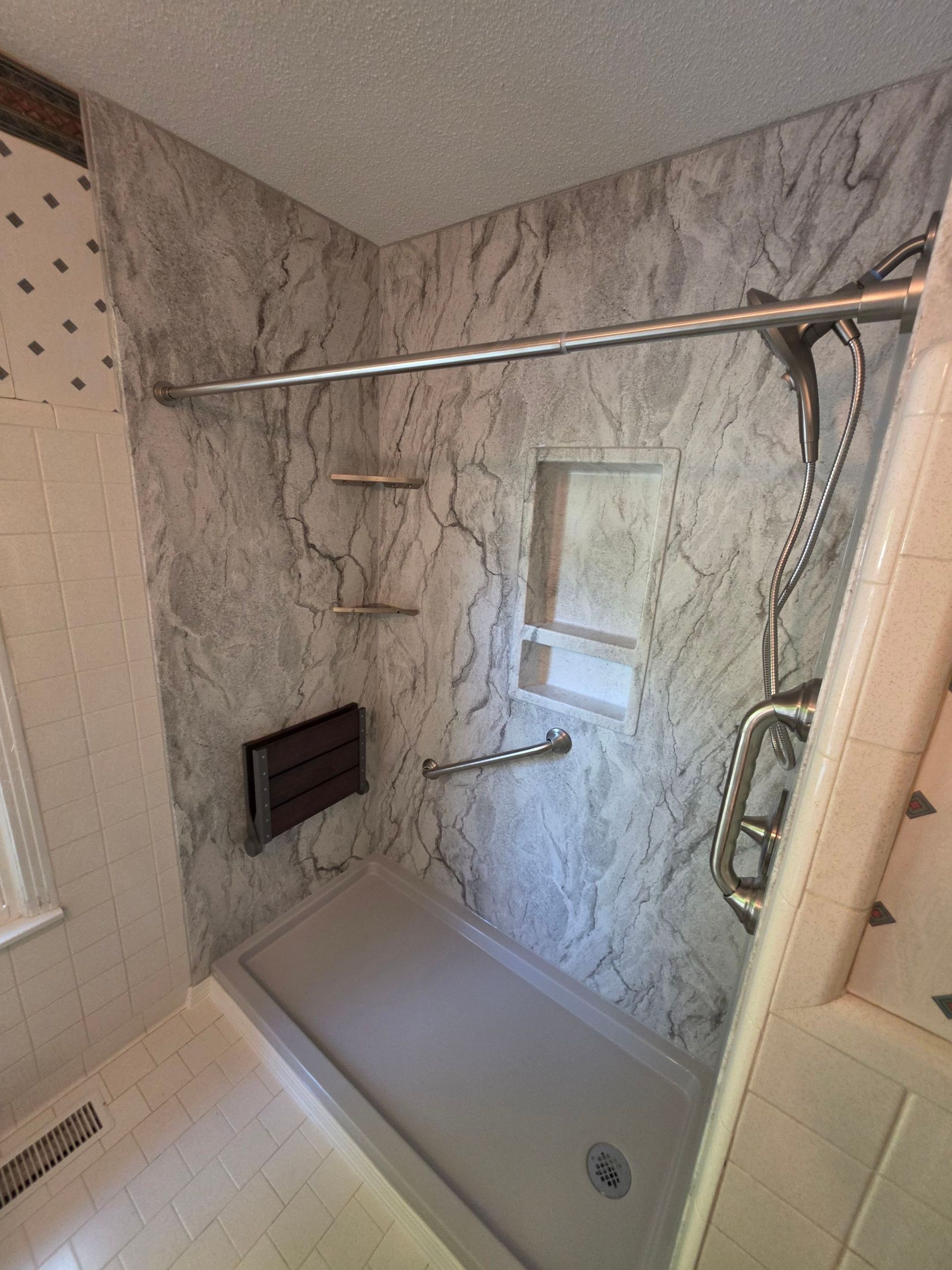 After: marble-look shower with niche and grab bar