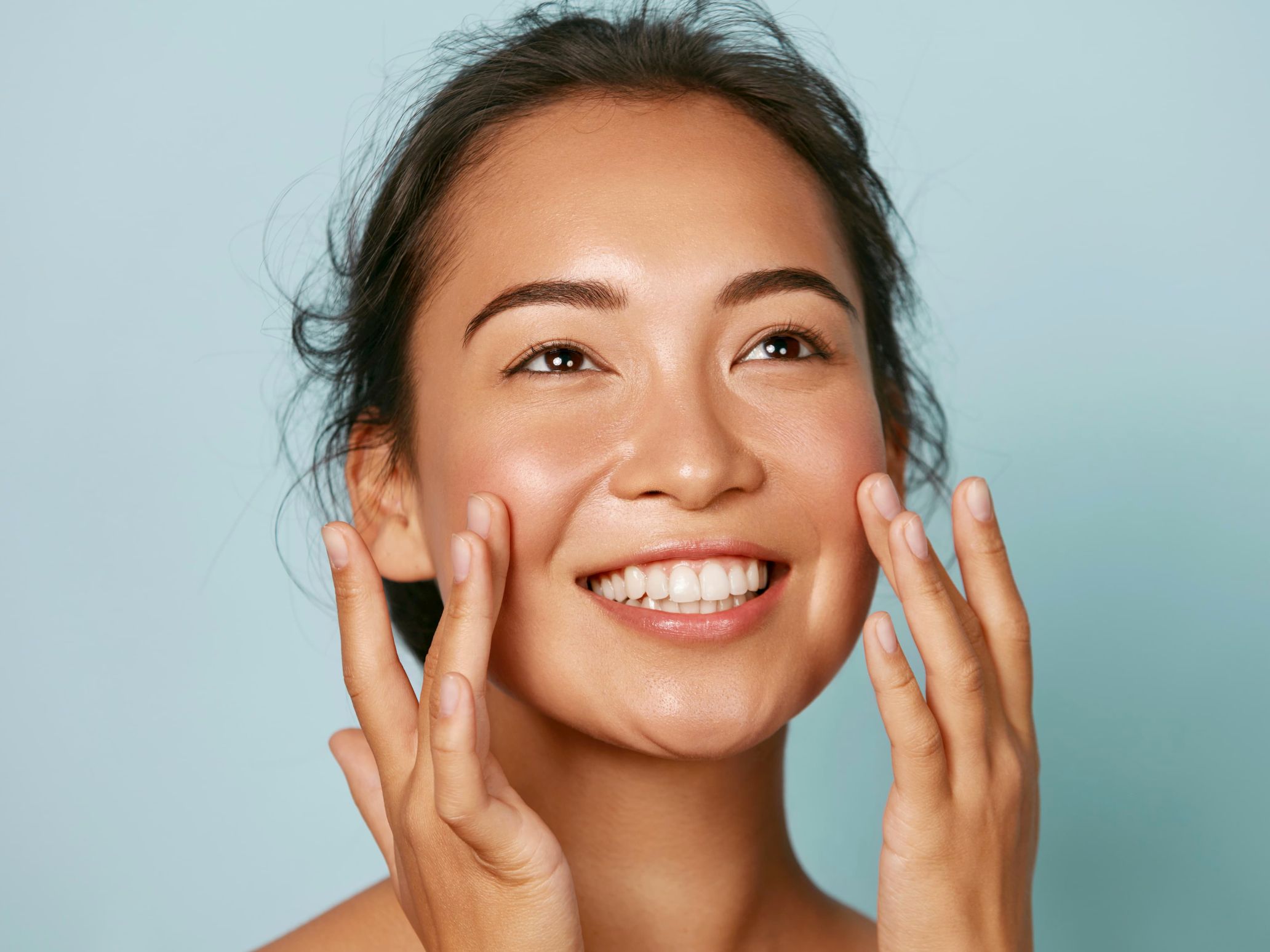 woman with natural bare face touching cheeks