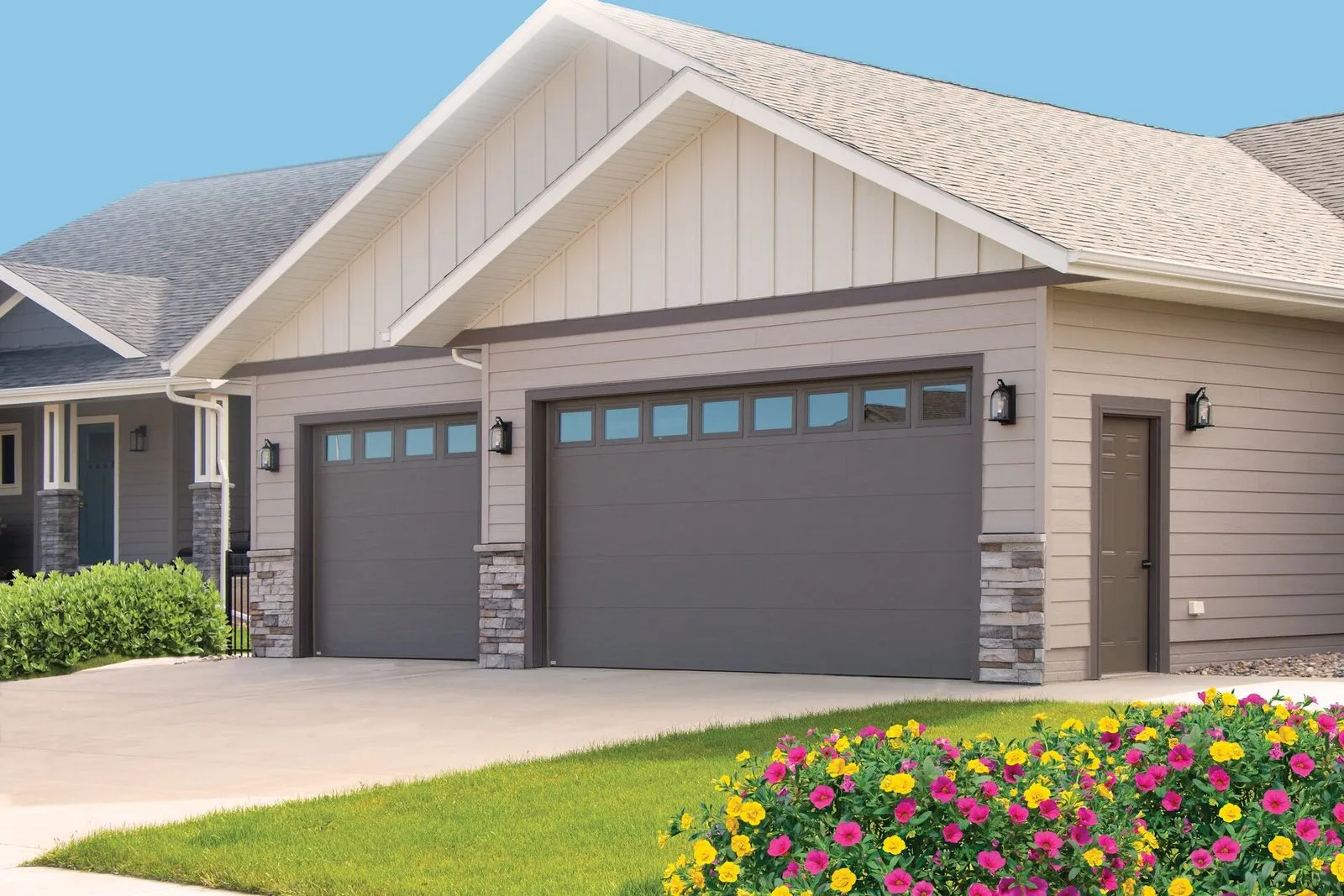 light colored single family home with brown garage doors
